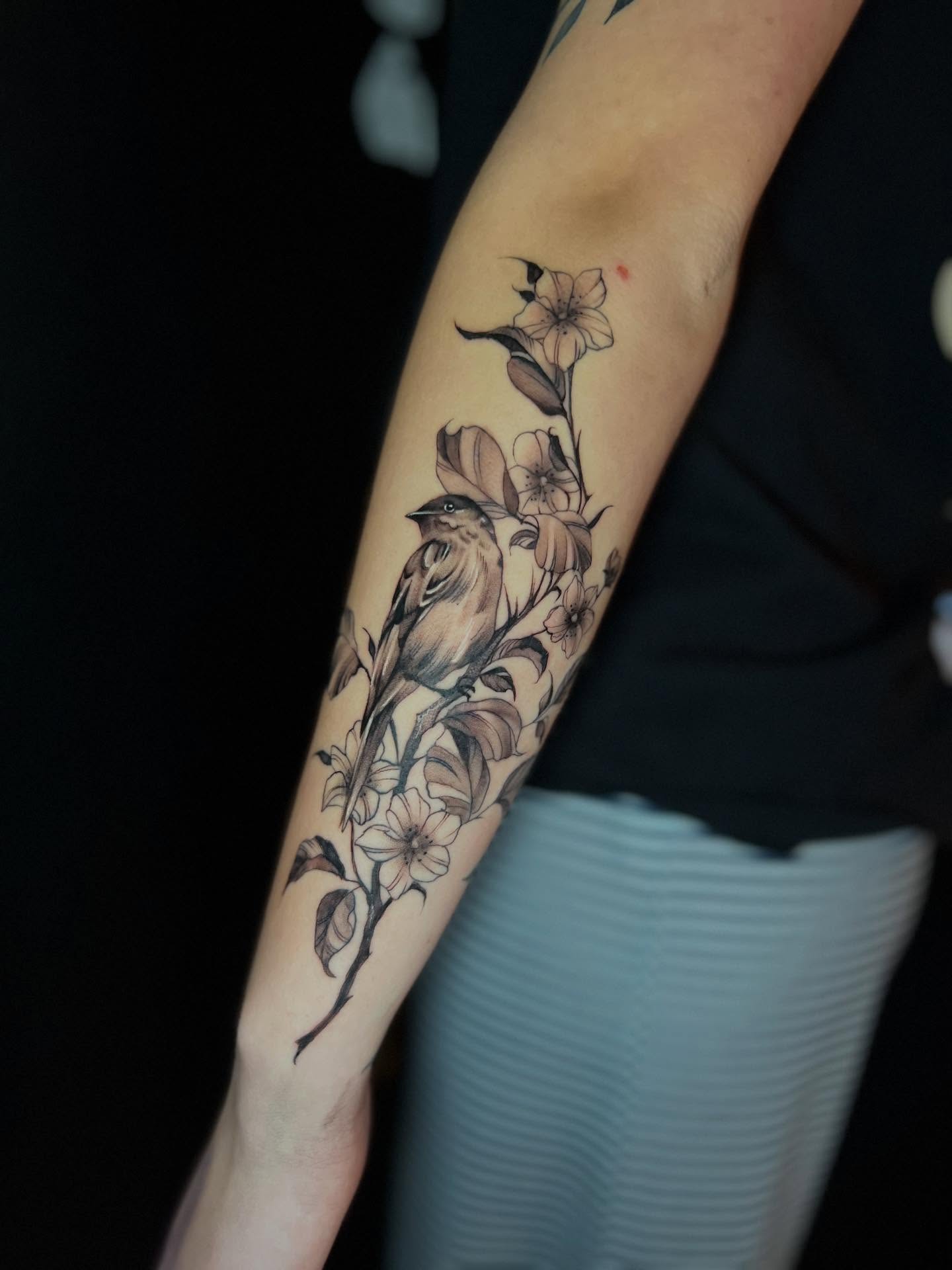 Bird and flowers realism tattoo on the forearm by Matthew Arguello