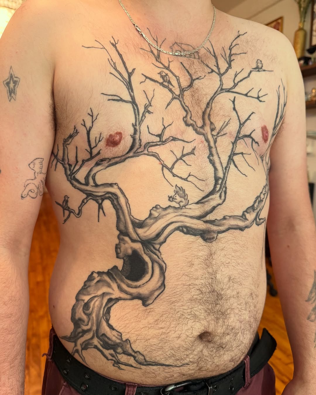 Gnarled tree with birds blackwork tattoo on the chest by marlena borscheid
