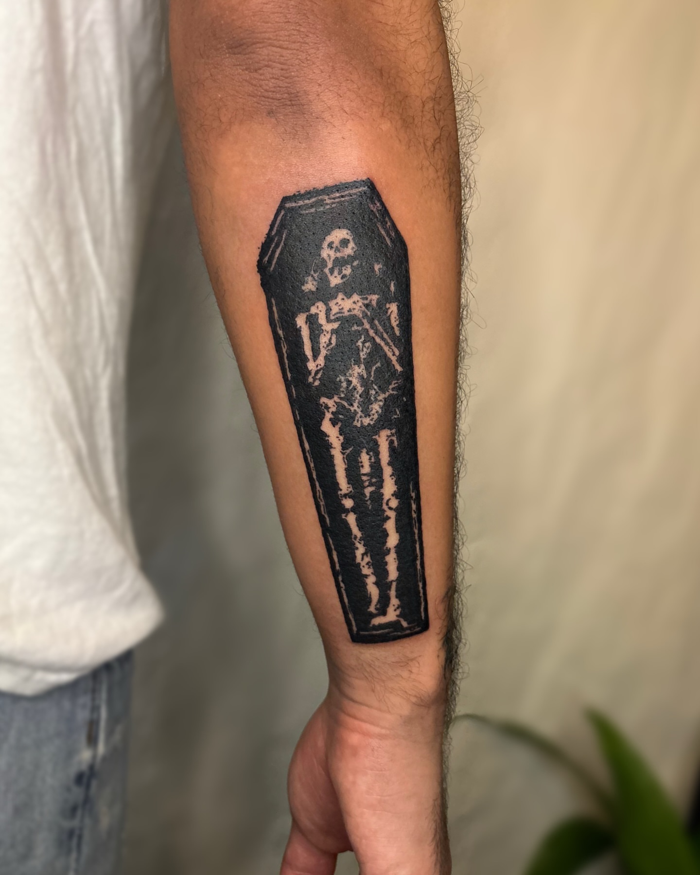 Coffin with skeleton black and grey tattoo on the forearm by Cooper, Portland, Oregon