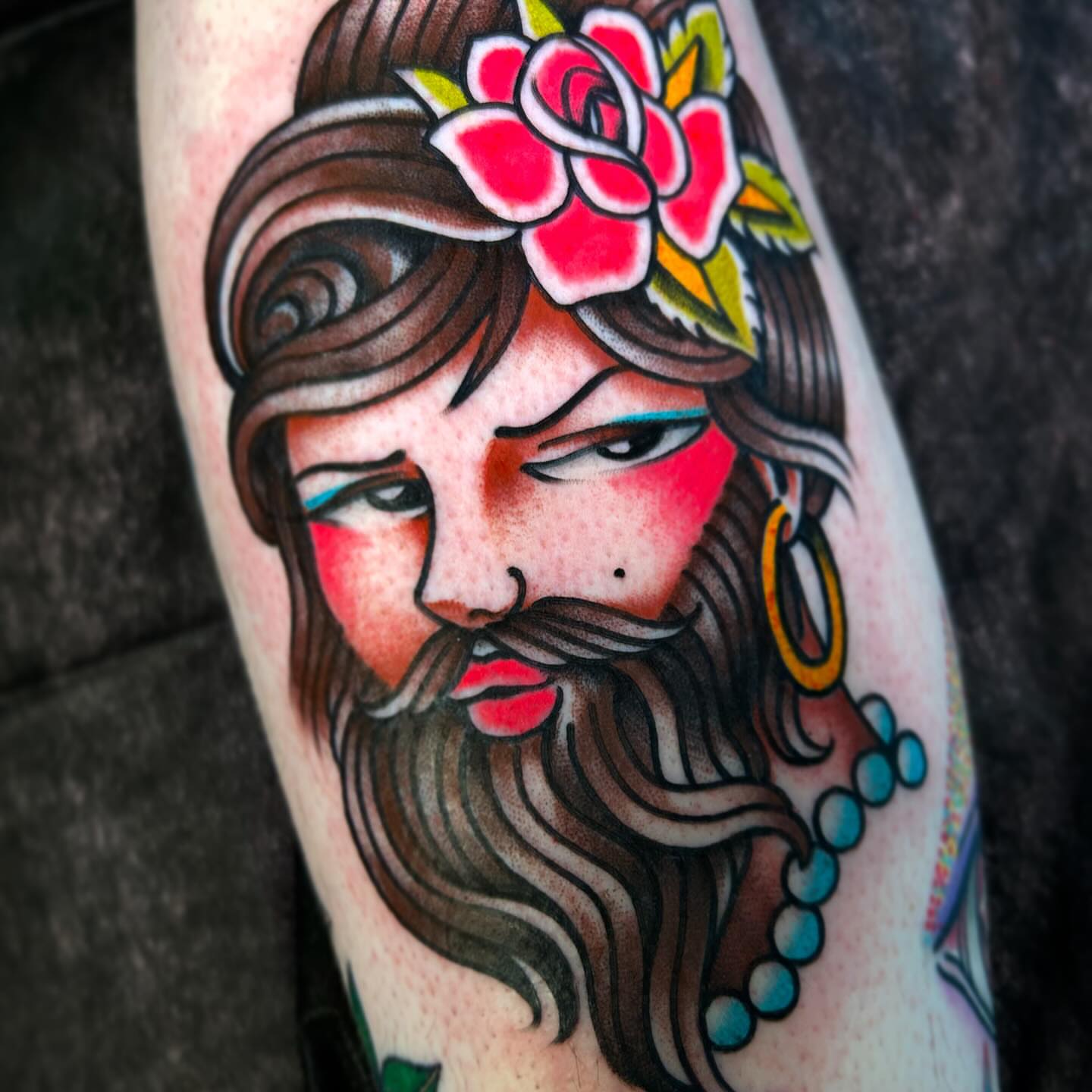 Bearded man with flower crown American traditional tattoo on the forearm by Katie Dexter, Des Moines, Iowa