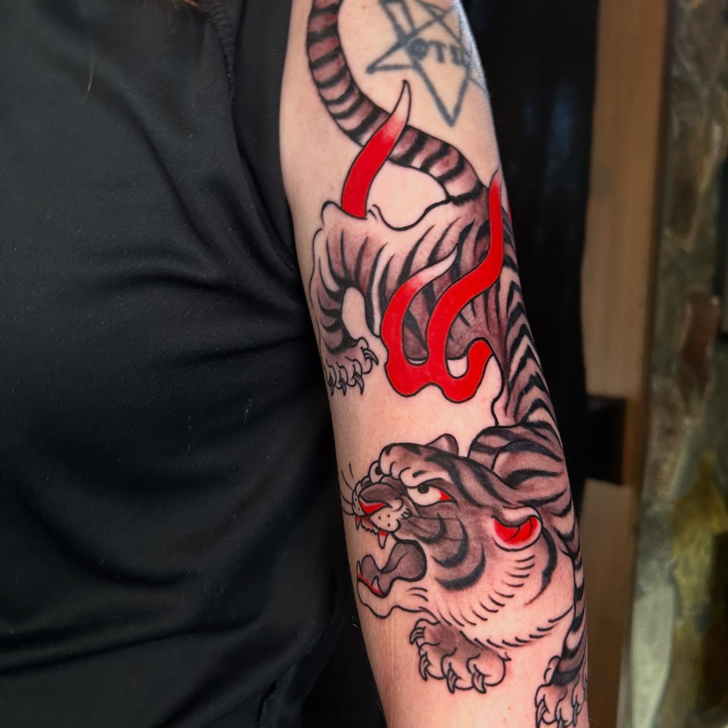 Tiger and dragon American traditional tattoo on the forearm by Katie Dexter, Des Moines, Iowa