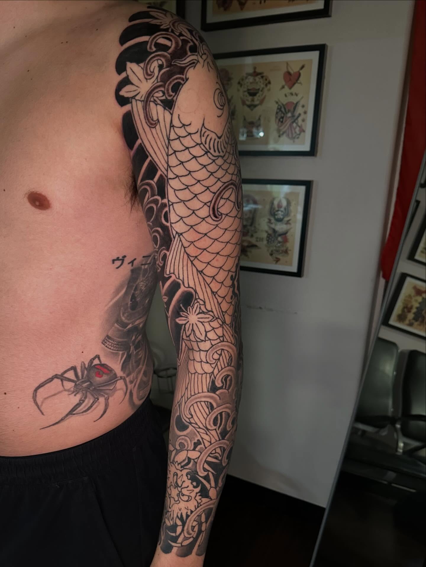 Koi fish japanese irezumi tattoo on the upper arm by Kenny Waizumi ๐
