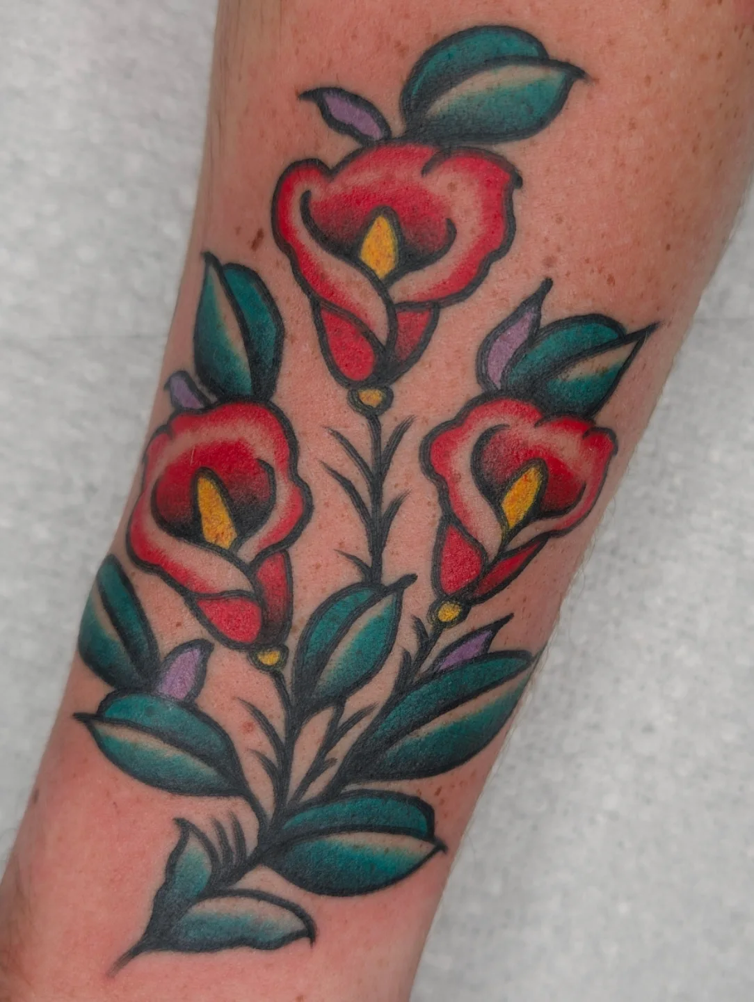 Calla lilies American traditional tattoo on the forearm by Aiden Krone, San Diego, California
