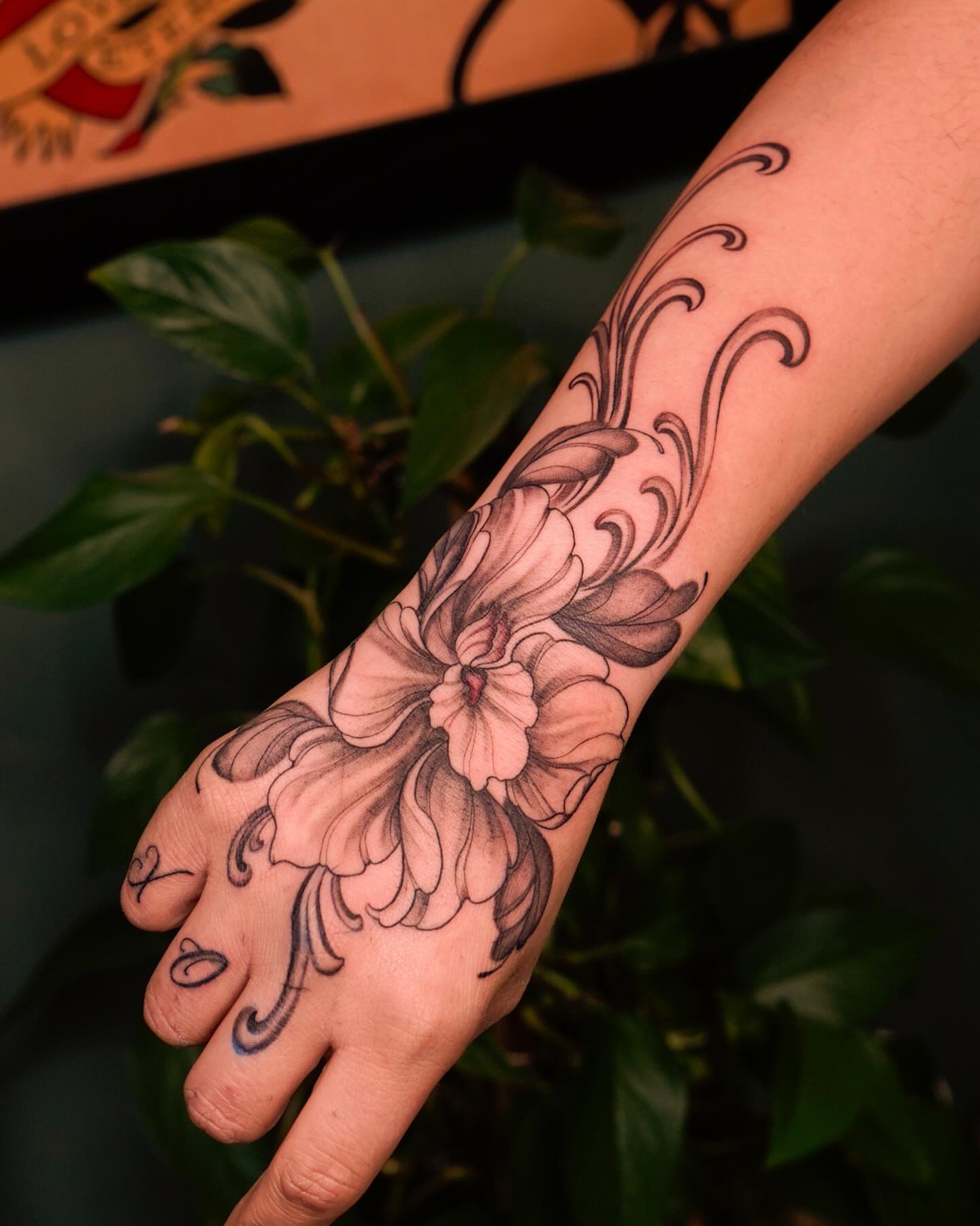 Floral design black and grey tattoo on the hand by Nicki Yến