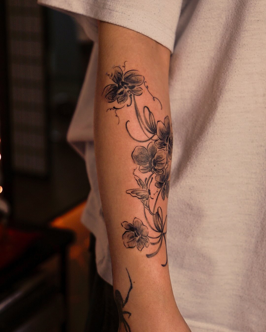 Floral arrangement black and grey tattoo on the forearm by Nicki Yến