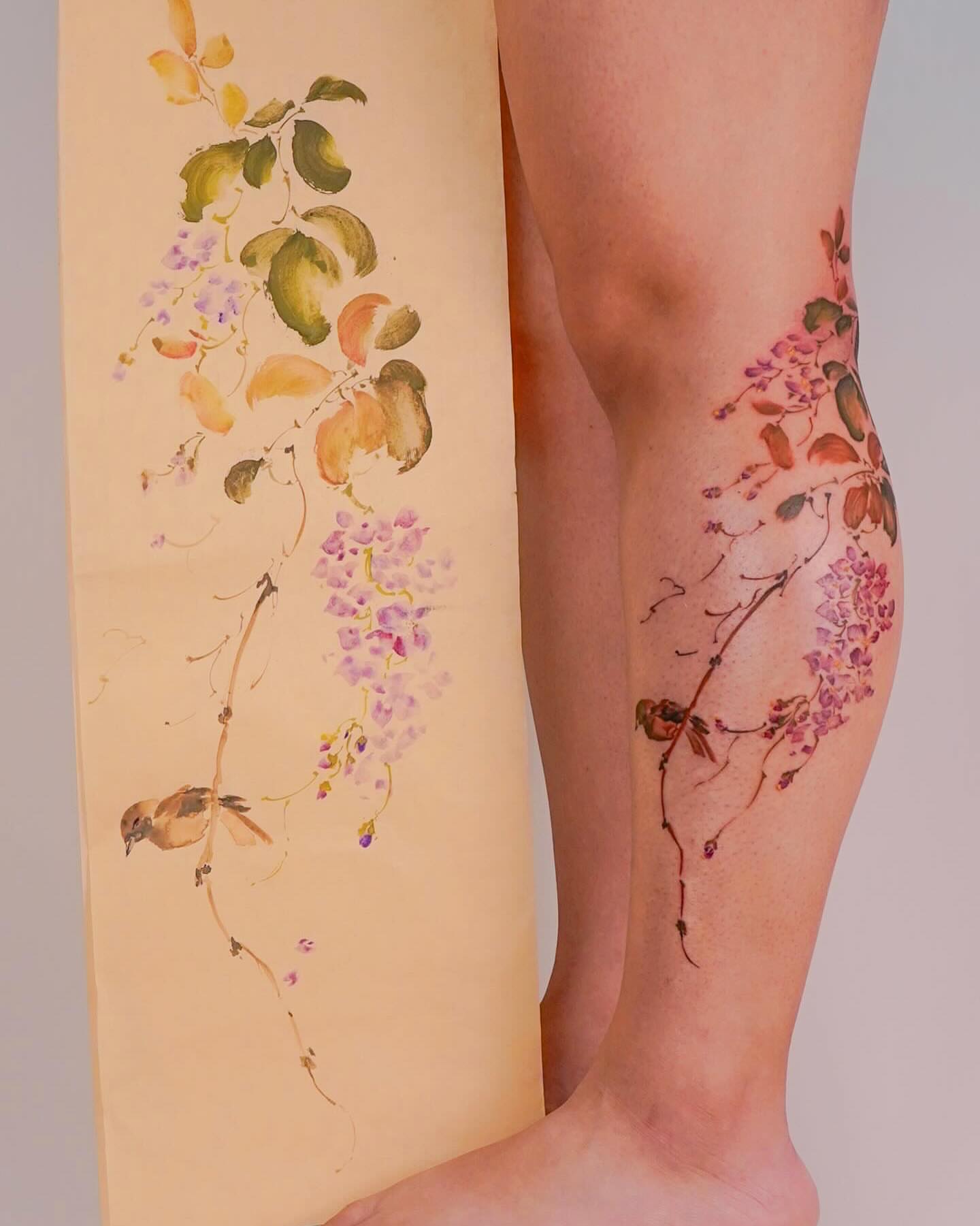 Wisteria and bird watercolor tattoo on the leg by Nicki Yến