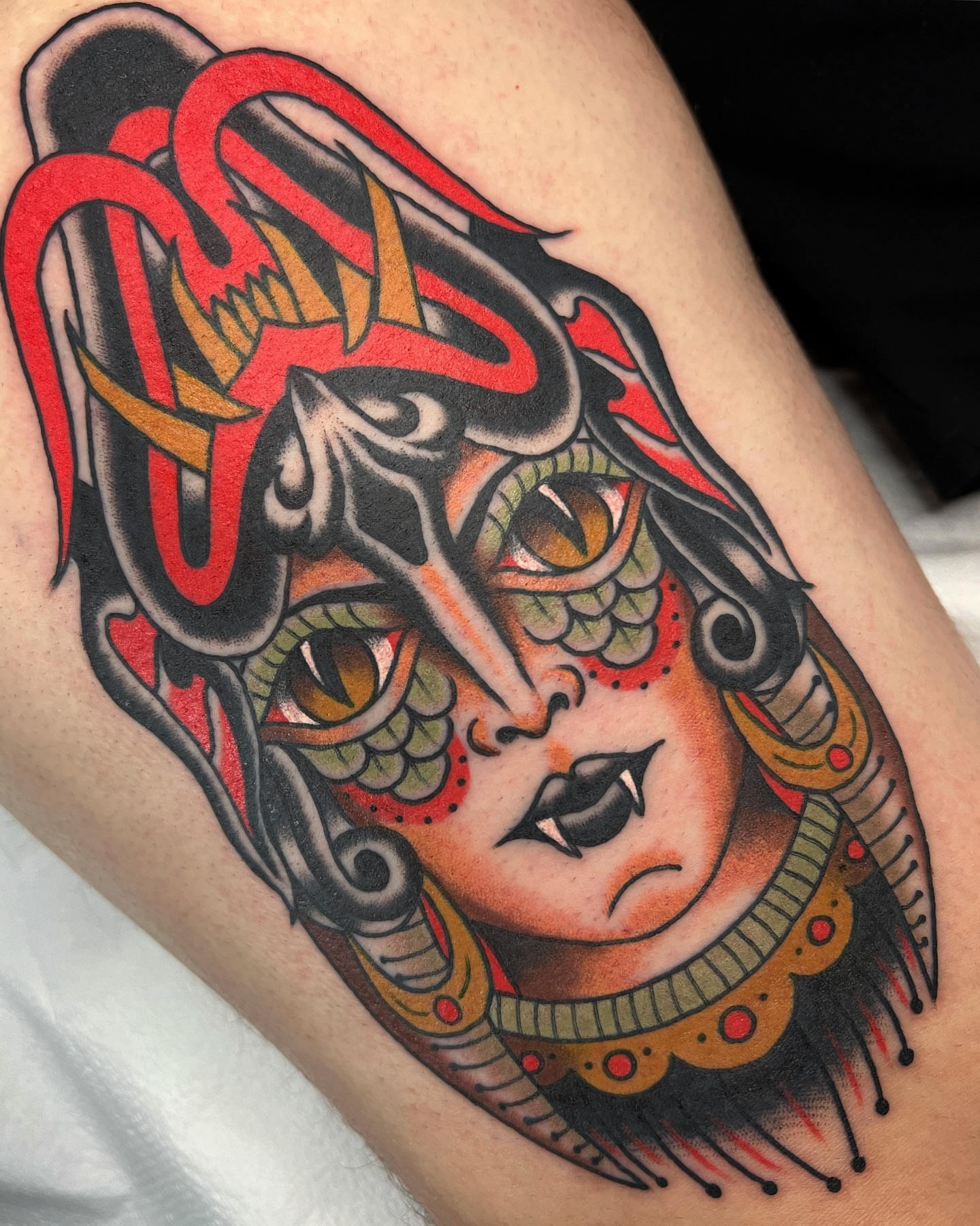 Woman with mask American traditional tattoo on the thigh by Cory Craft