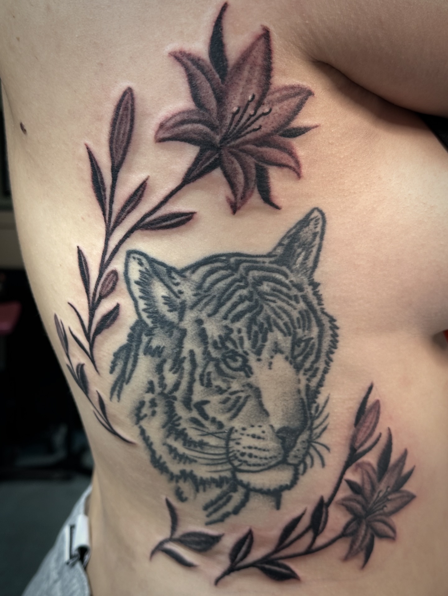 Tiger and lilies realism tattoo on the ribs by Chris Blanchard