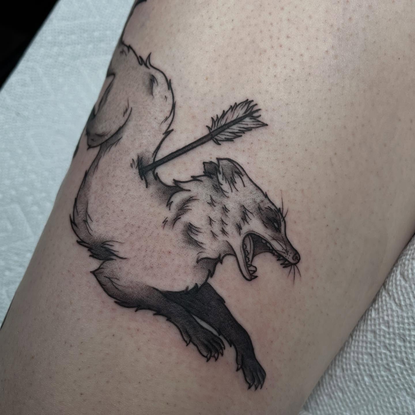 Badger with arrow black and grey tattoo on the thigh by Ty’s Tattoos