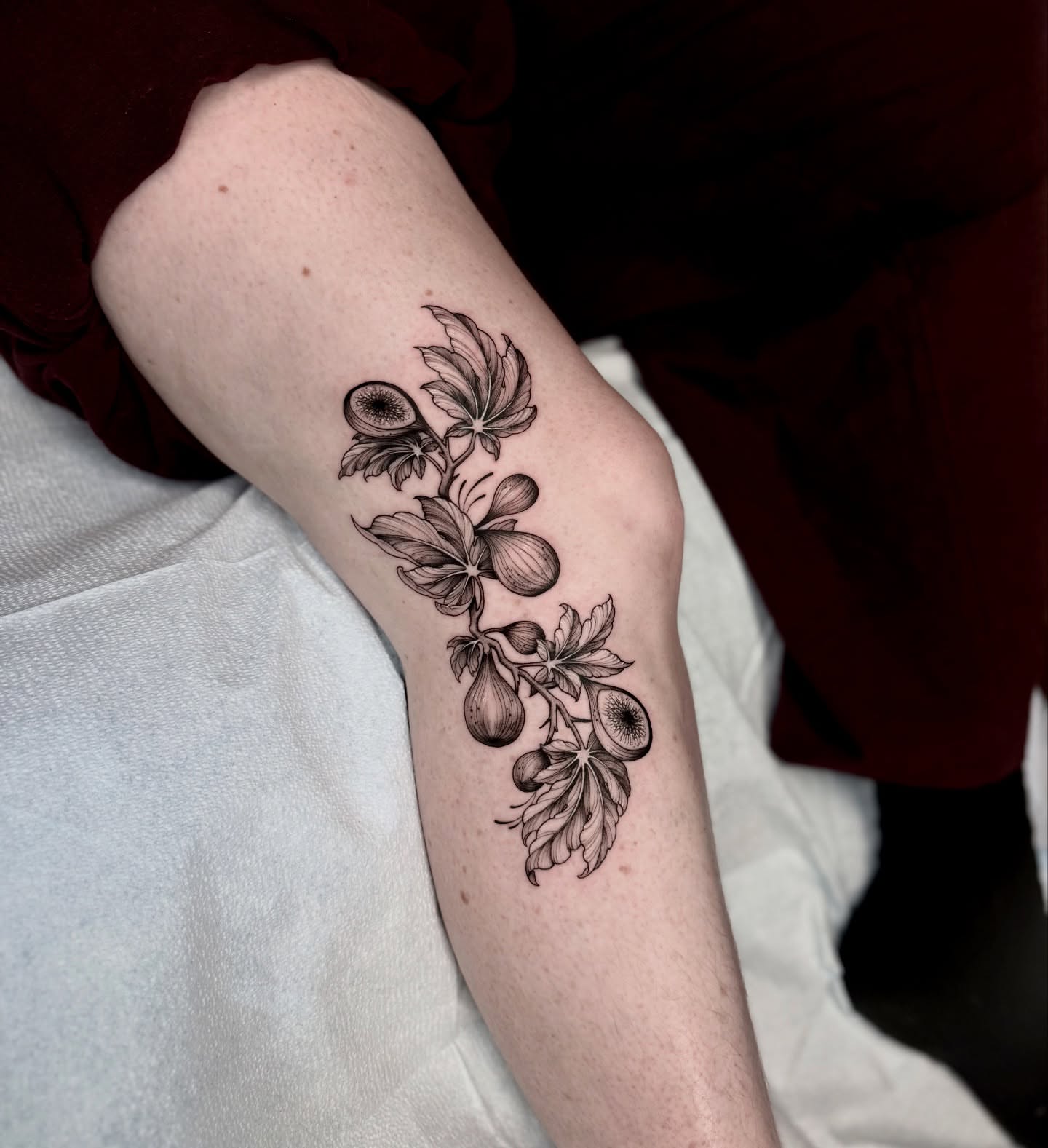 Flower and seed pod black and grey tattoo on the forearm by Kathryn Semus
