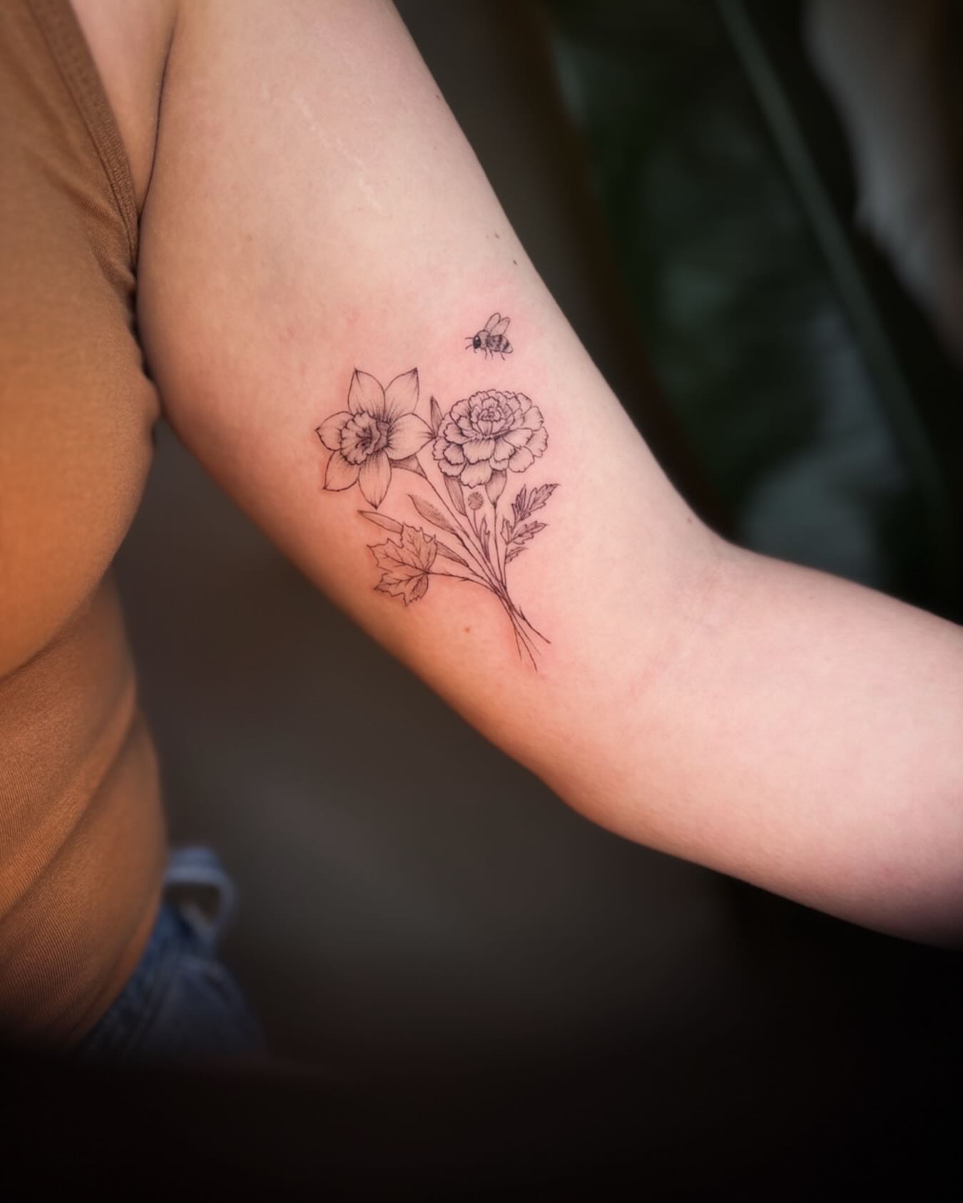 Flowers and bee fine line tattoo on the forearm by Ashley Pilgreen