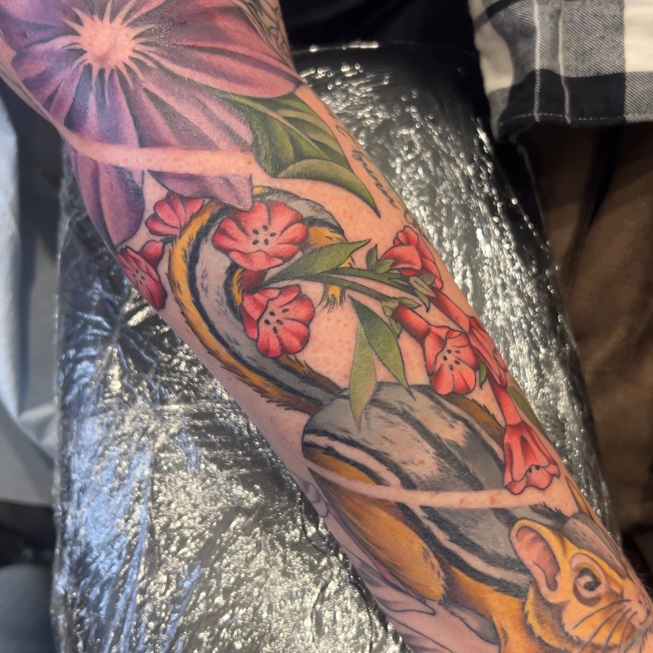 Chameleon and flowers new school tattoo on the forearm by Blu