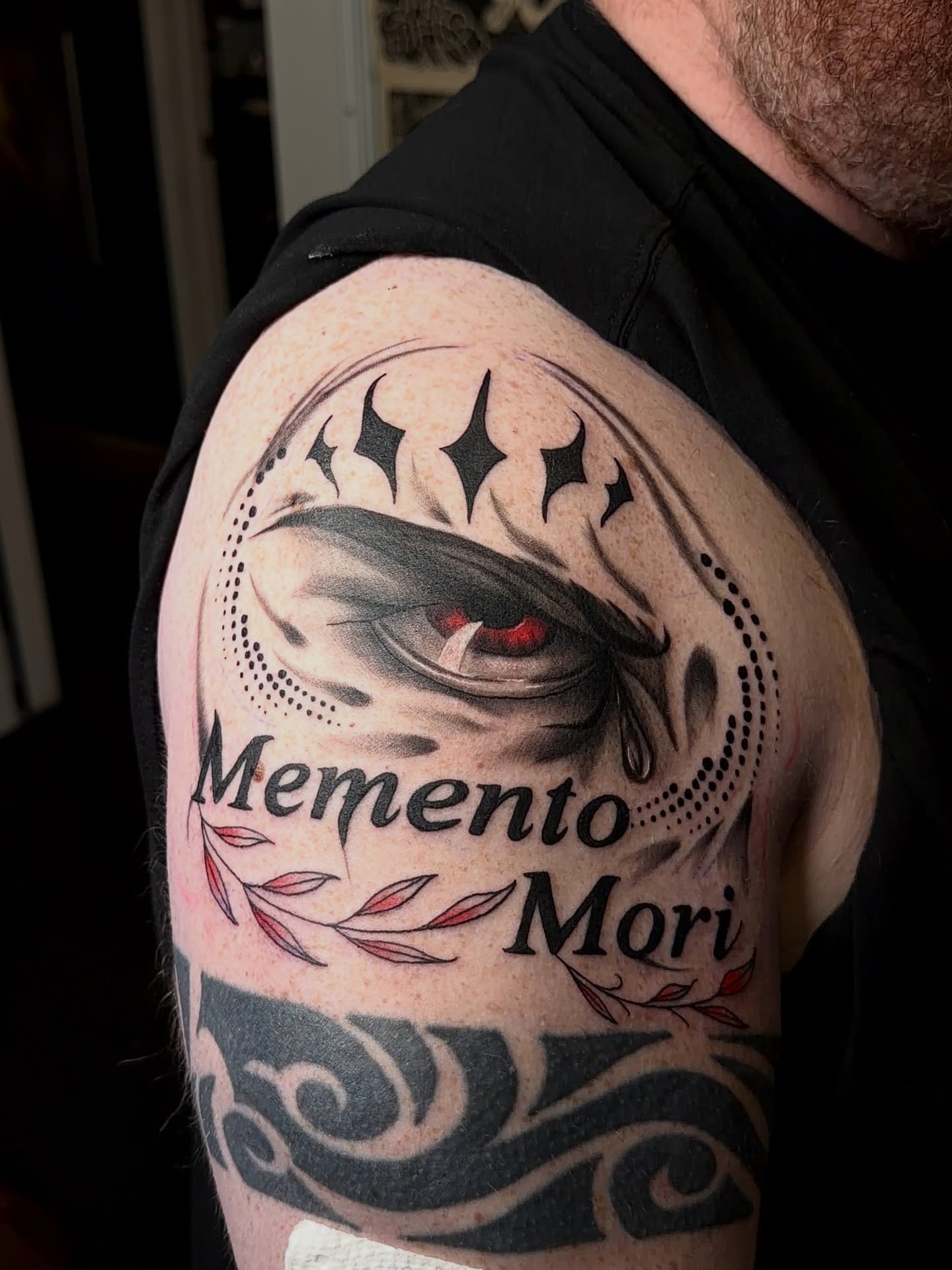 Eye with 'Memento Mori' dark realism tattoo on the shoulder by Denis Seregin