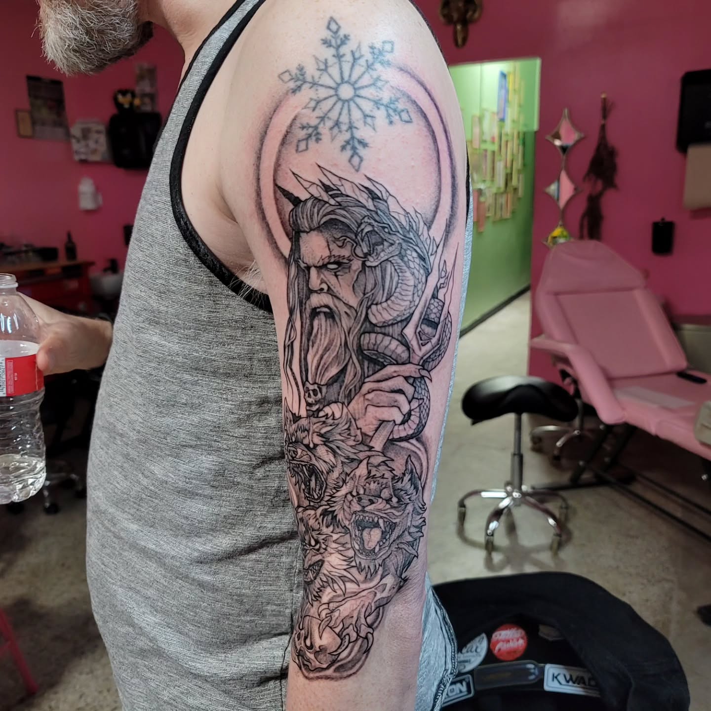 Bearded man with dragon realism tattoo on the forearm by Mary Lefeau