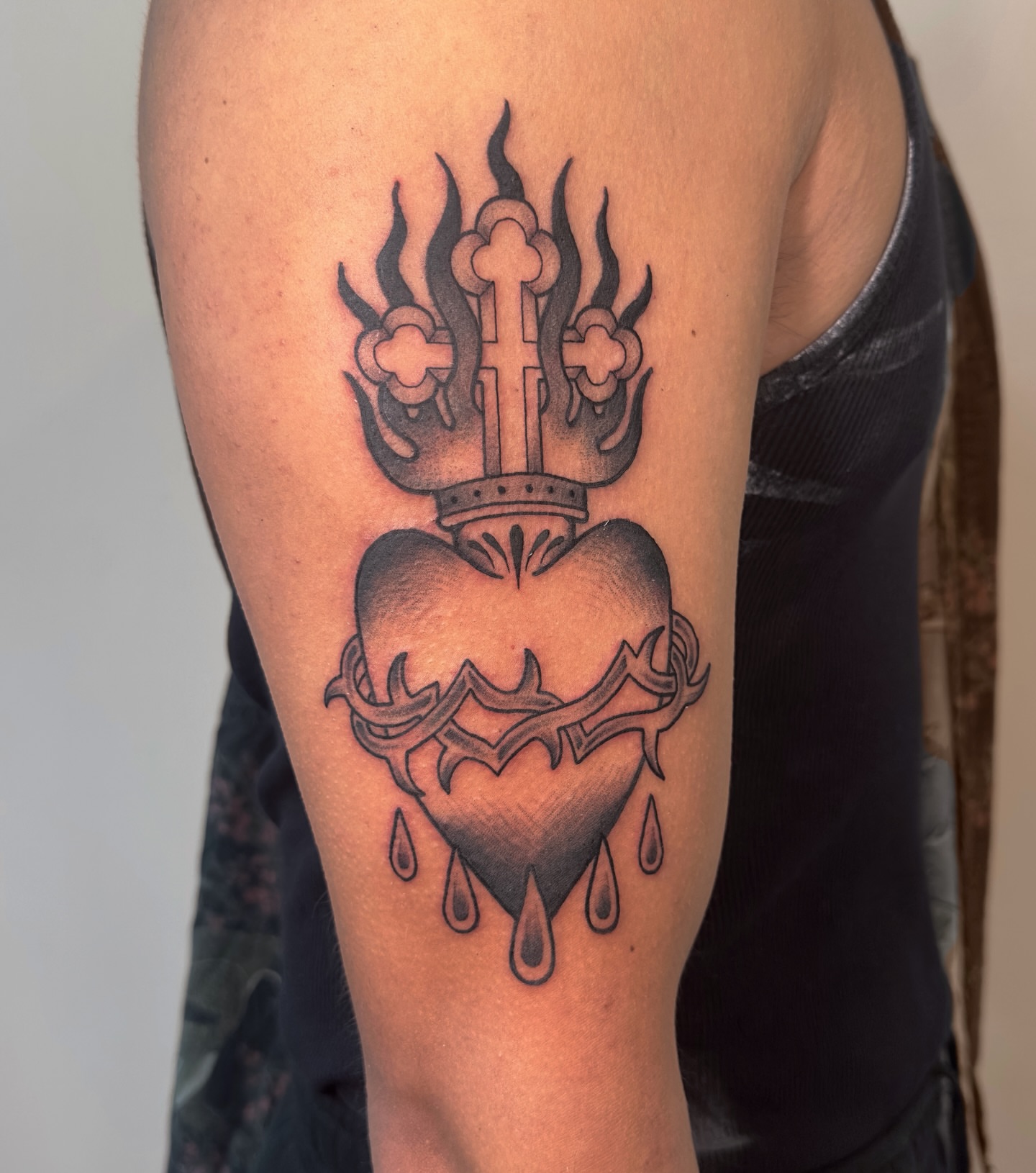 Heart with cross and flames black and grey tattoo on the forearm by Kail