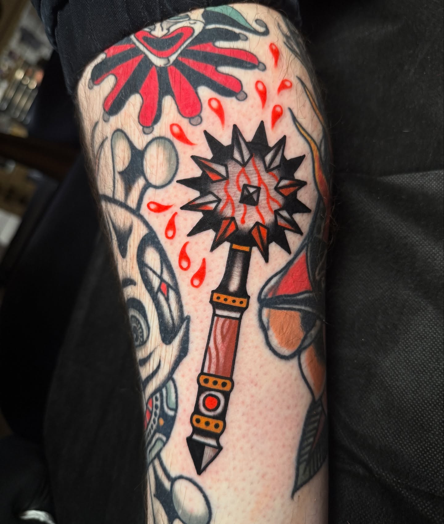 Jester hat and dagger American traditional tattoo on the forearm by Chaz Otto
