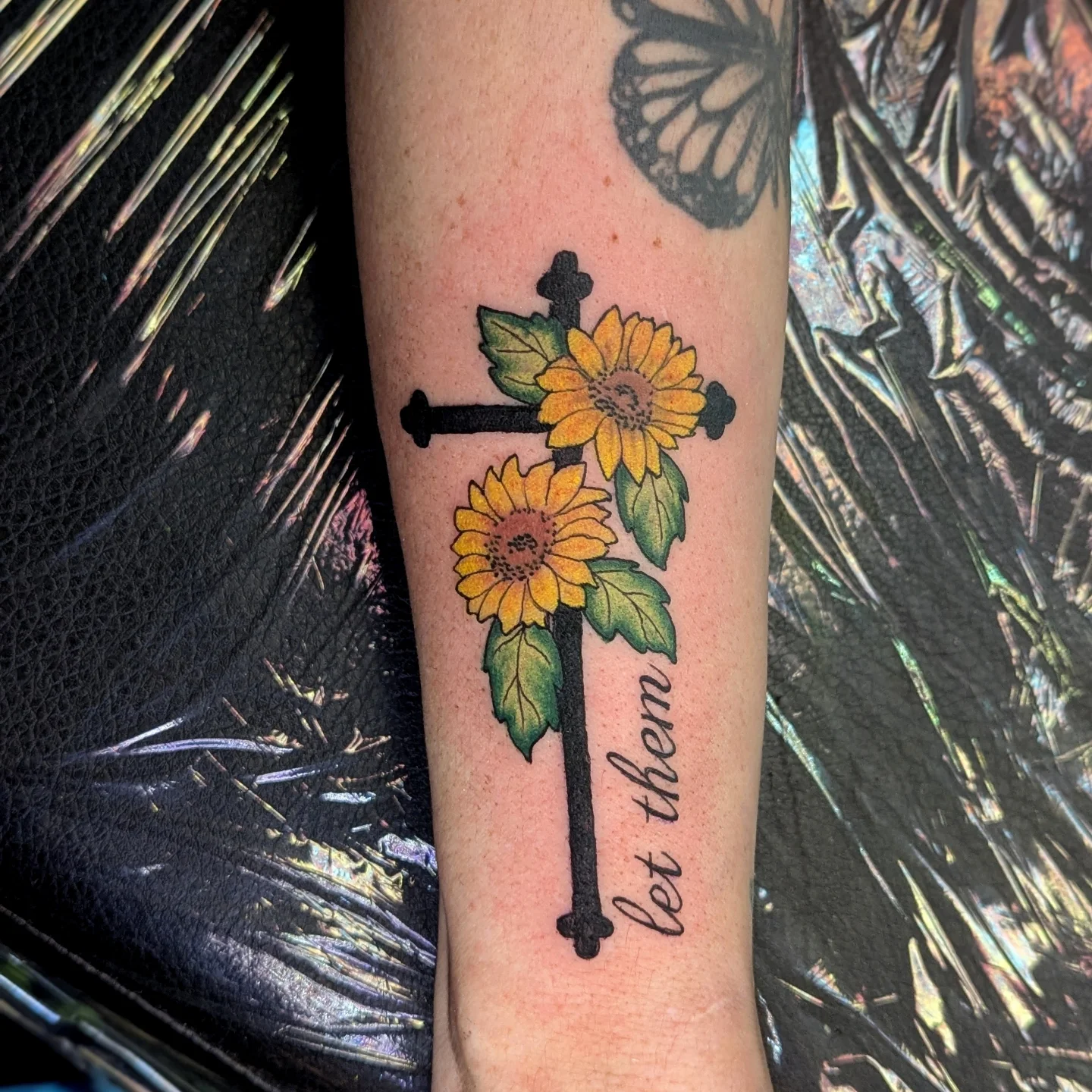 Sunflower cross neo-traditional tattoo on the forearm by Bethany Jane Tattoos