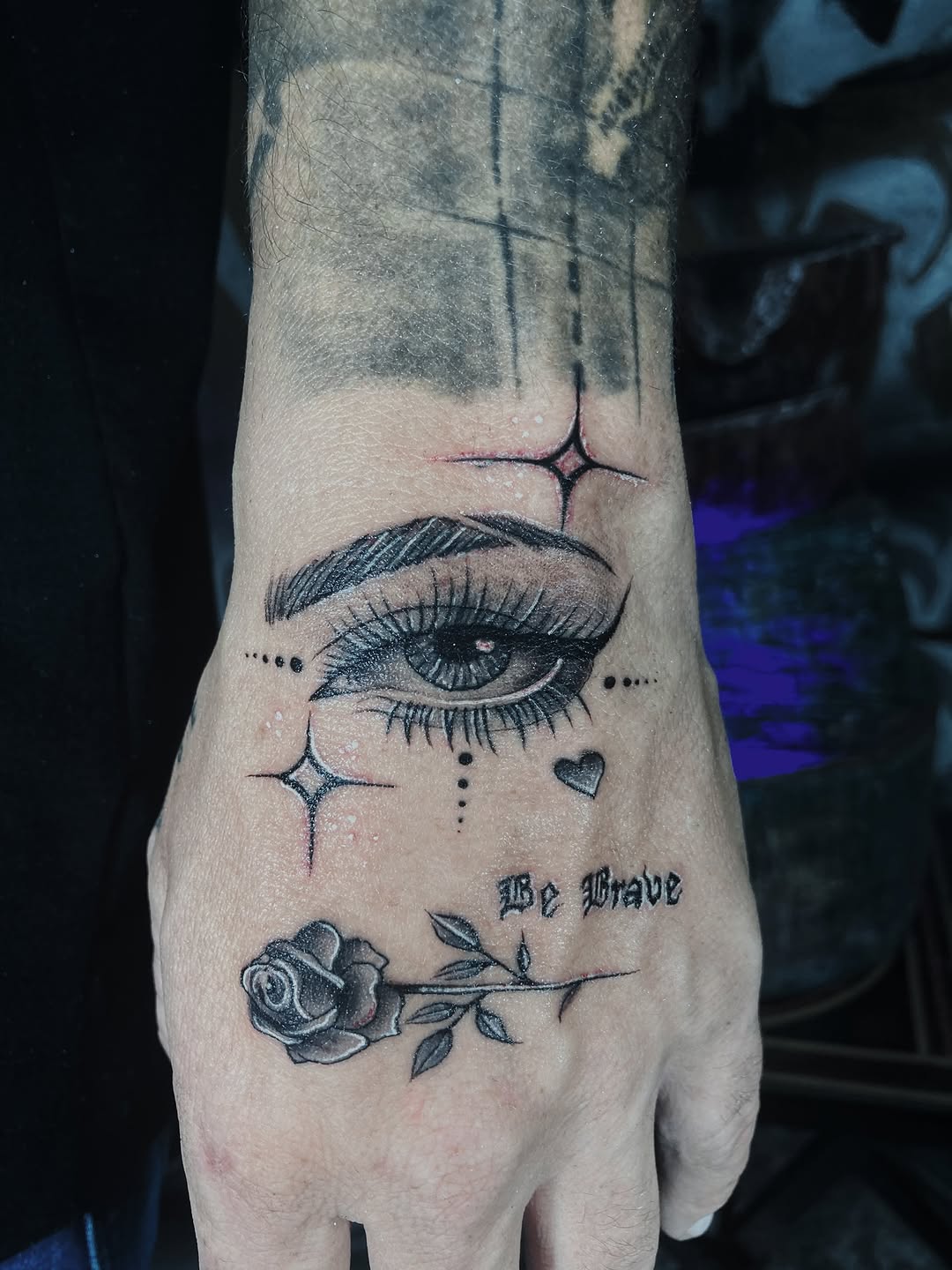 Eye and rose with script watercolor tattoo on the hand by Alvaro