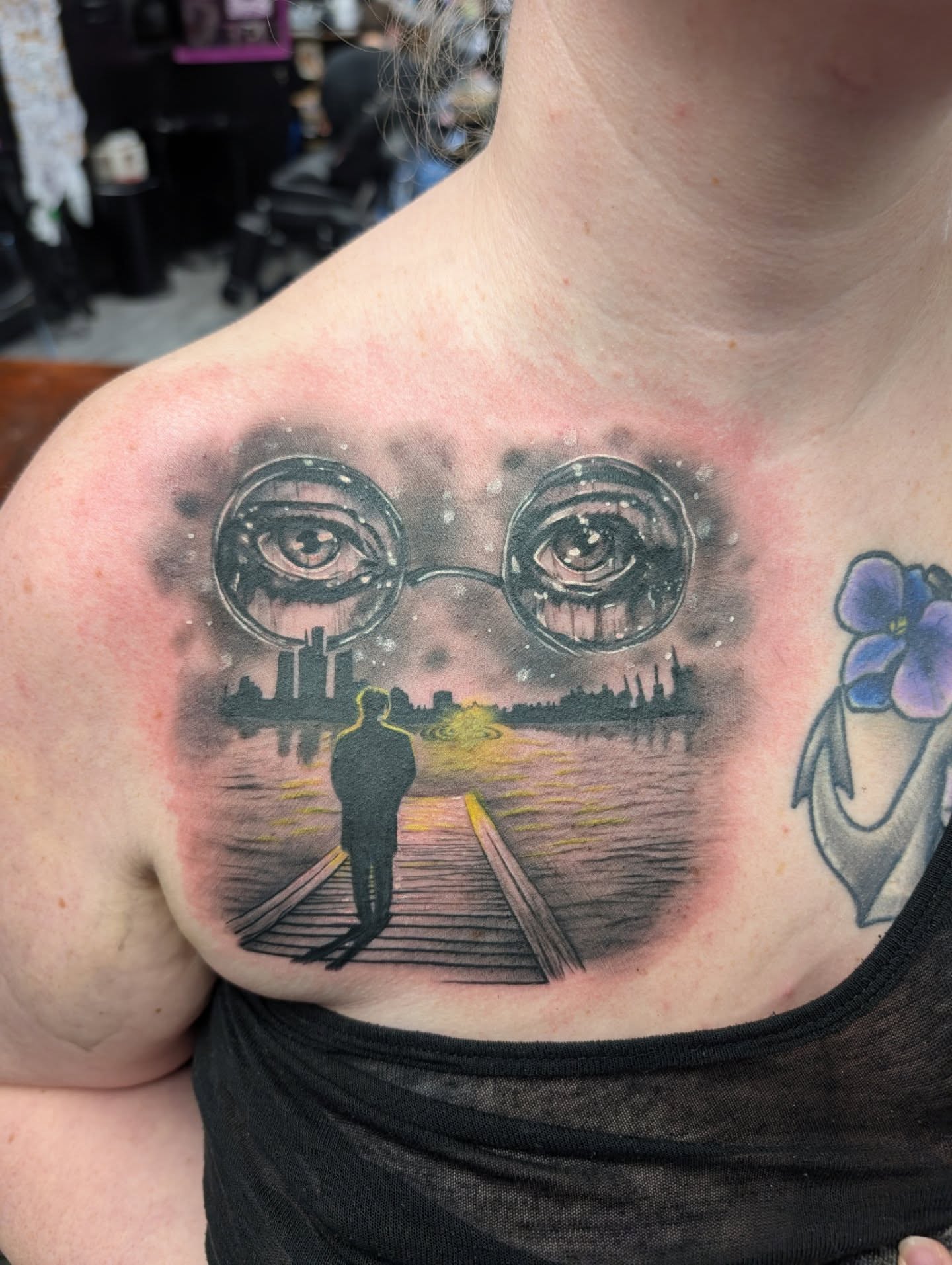 Eyes and cityscape realism tattoo on the chest by Kara Falcon