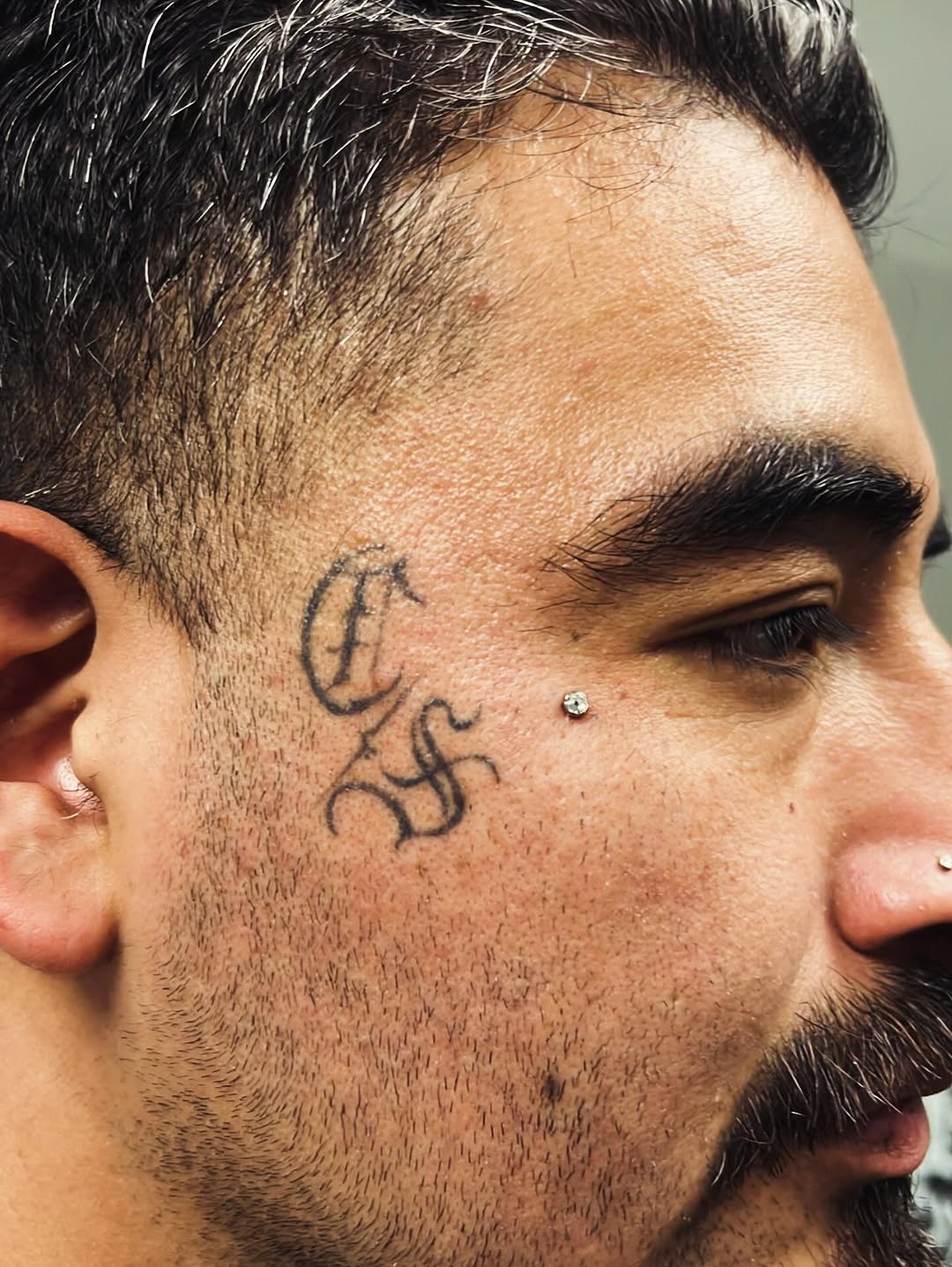 Script lettering on face tattoo on the head by Renzoe_piercingz