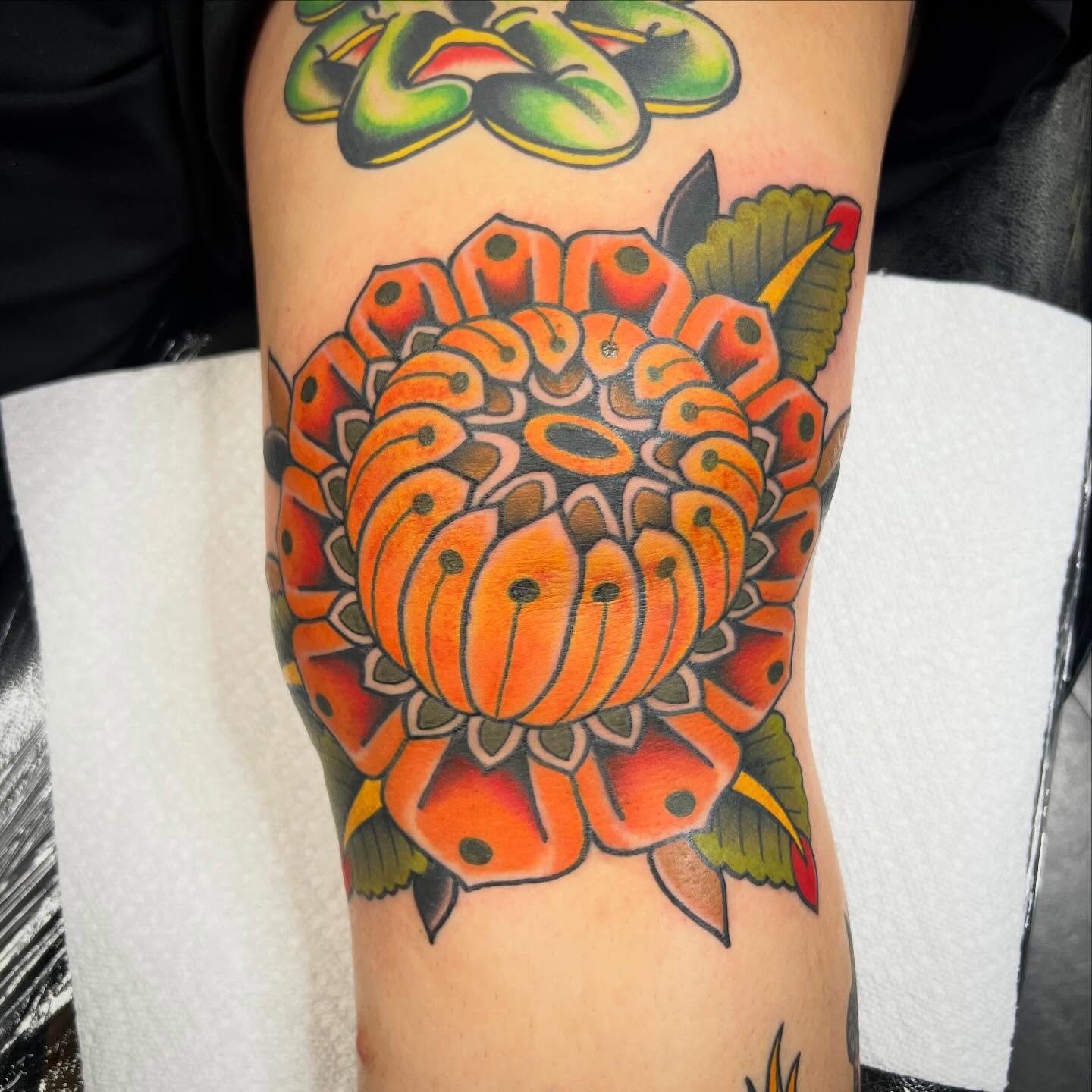 Chrysanthemum American traditional tattoo on the forearm by Taylor Estrella