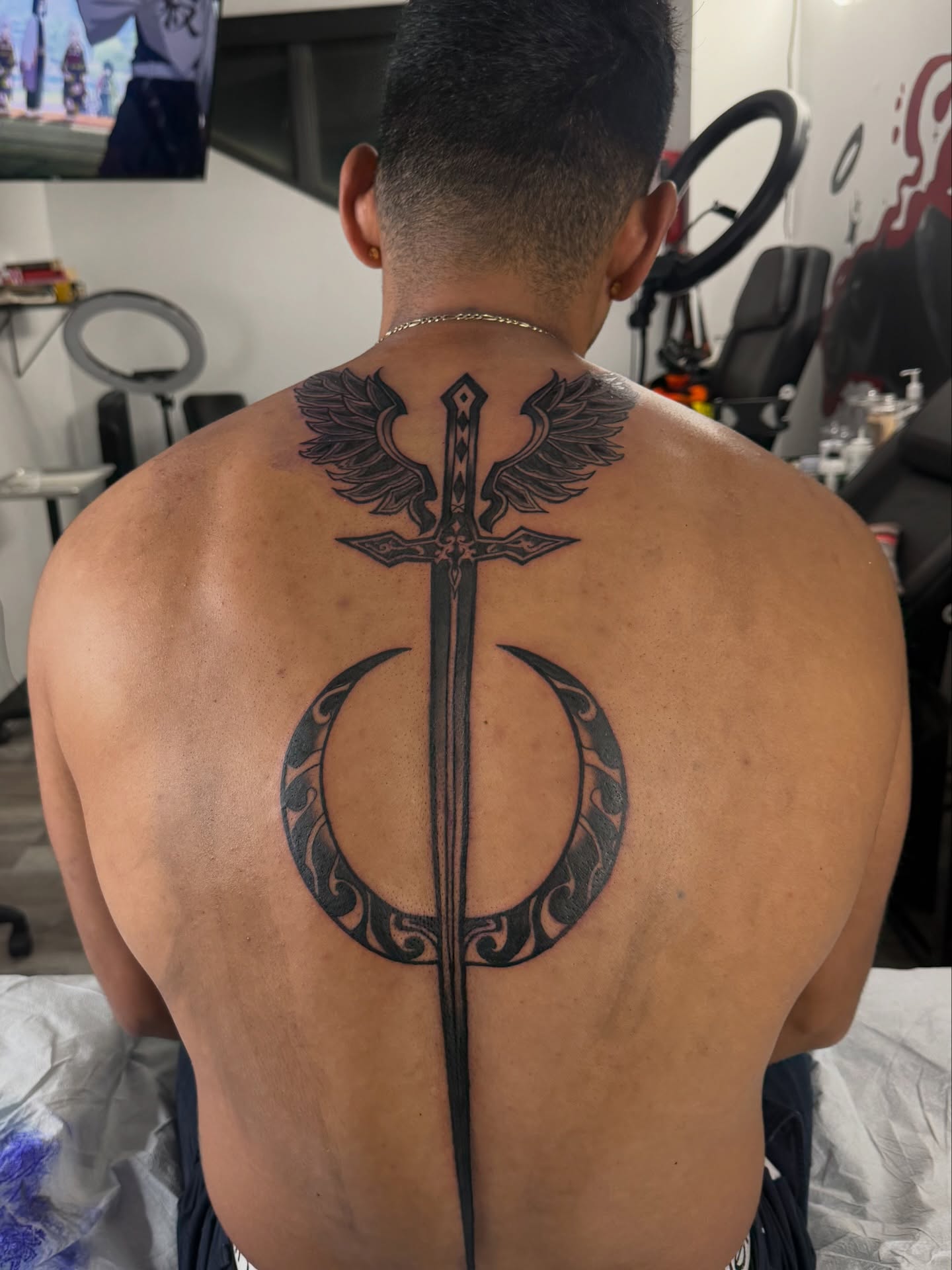 Sword and wings tribal tattoo on the back by Atlanta Tattoo Artist