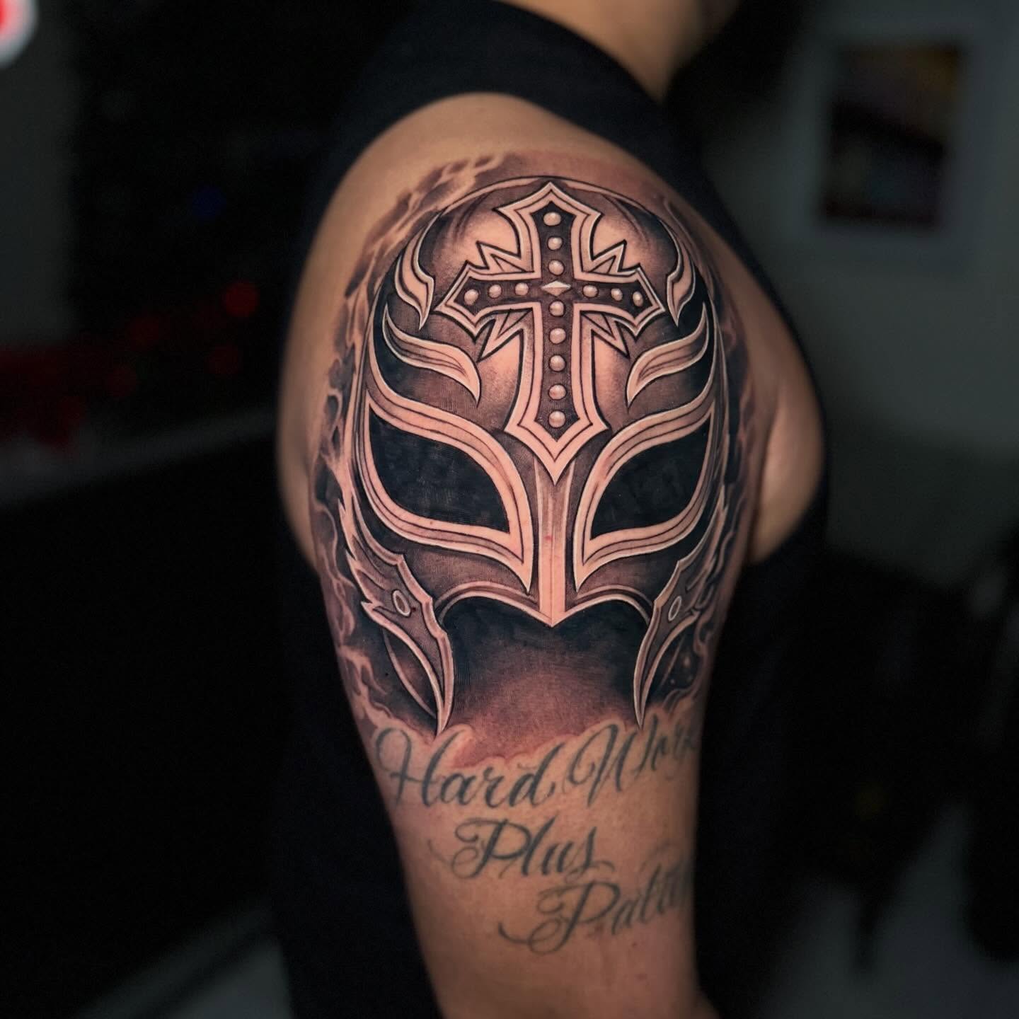 Cross mask geometric tattoo on the shoulder by Flames, Cerritos, California