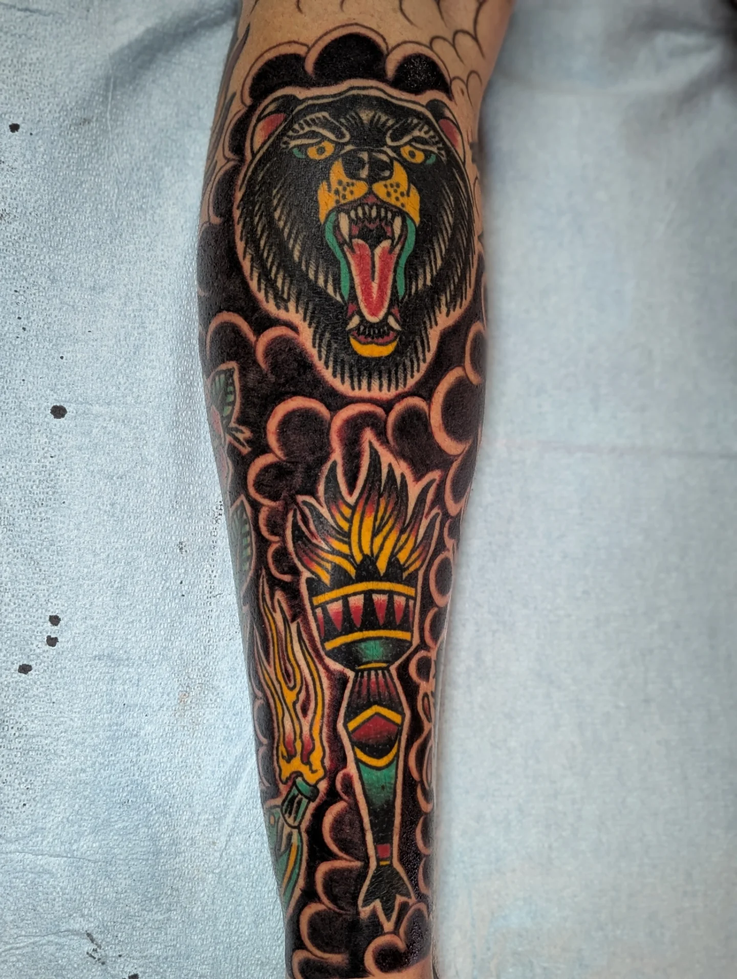 Bear and torch American traditional tattoo on the forearm by Eric Ward