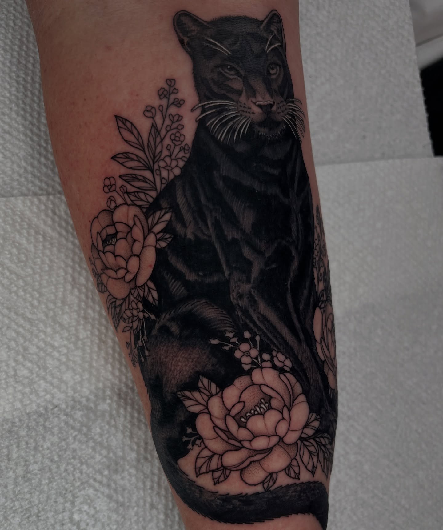 Panther and flowers realism tattoo on the forearm by Jordan Hunt
