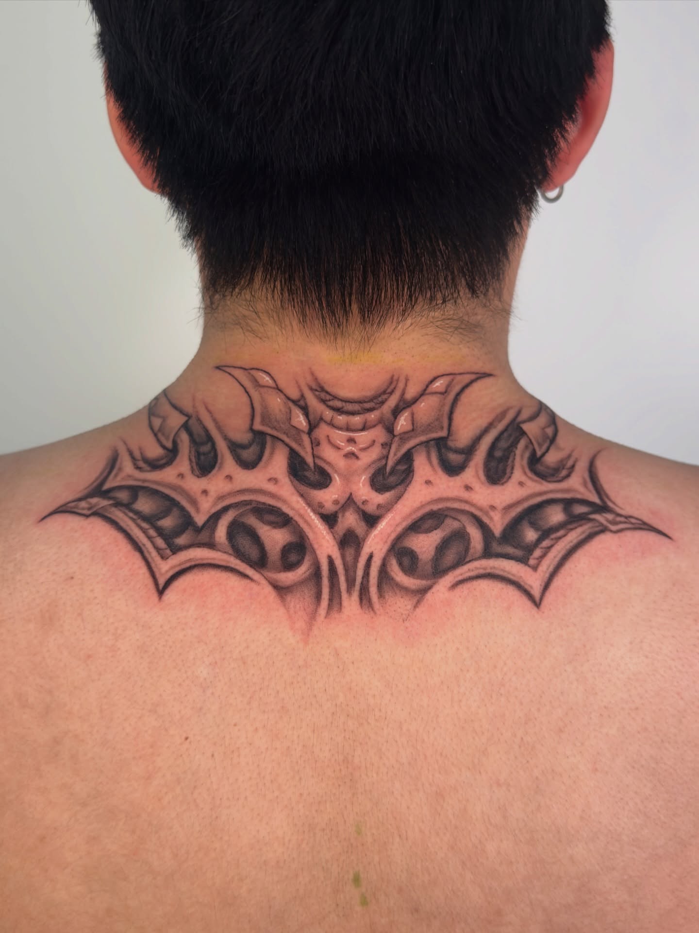 Bat wings geometric tattoo on the neck by Diana