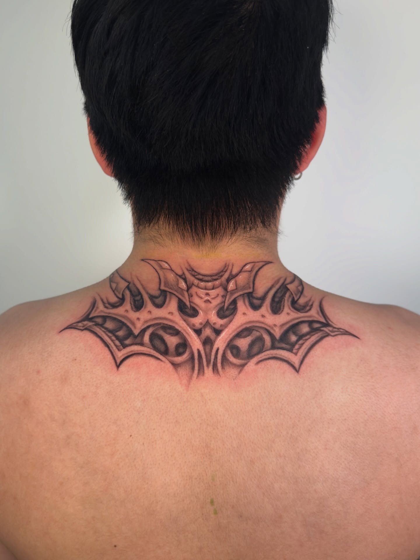 Bat wings geometric tattoo on the neck by Diana