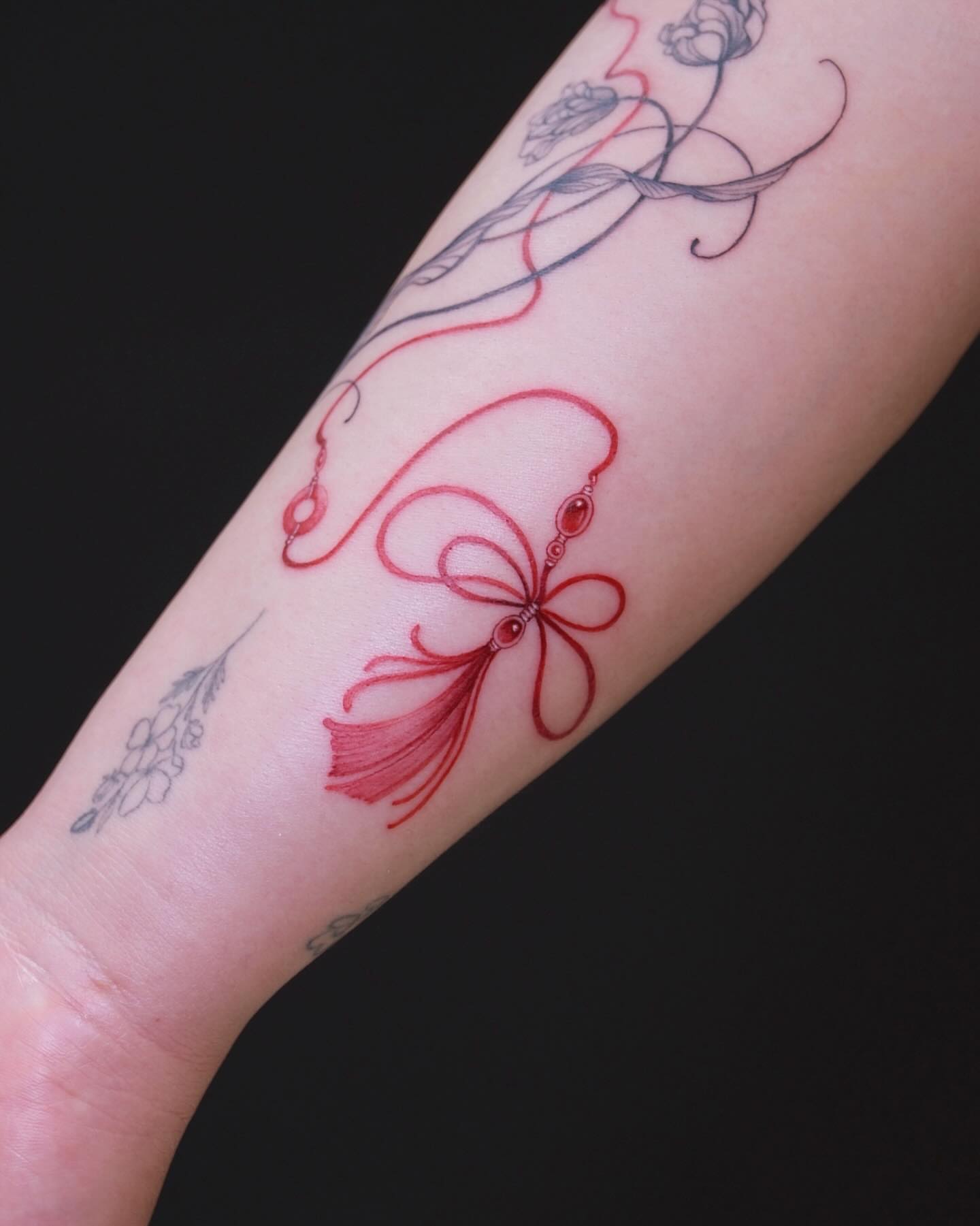 Bow and ribbon new school tattoo on the forearm by MJ tattooist