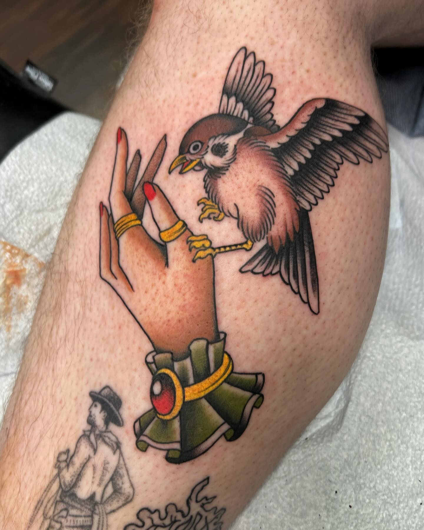 Bird perched on hand American traditional tattoo on the forearm by Jade McKenzie, Temecula, California