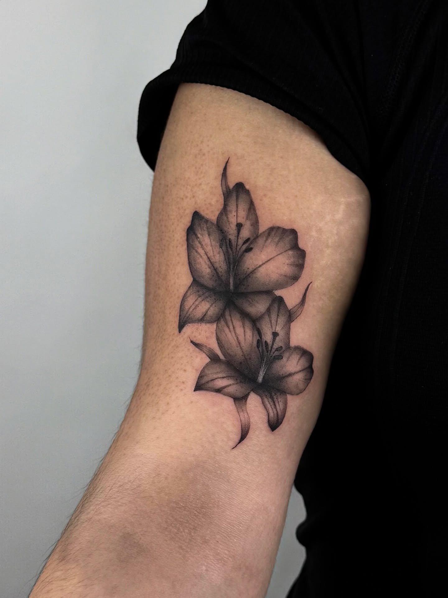 Lilies black and grey tattoo on the forearm by sabina