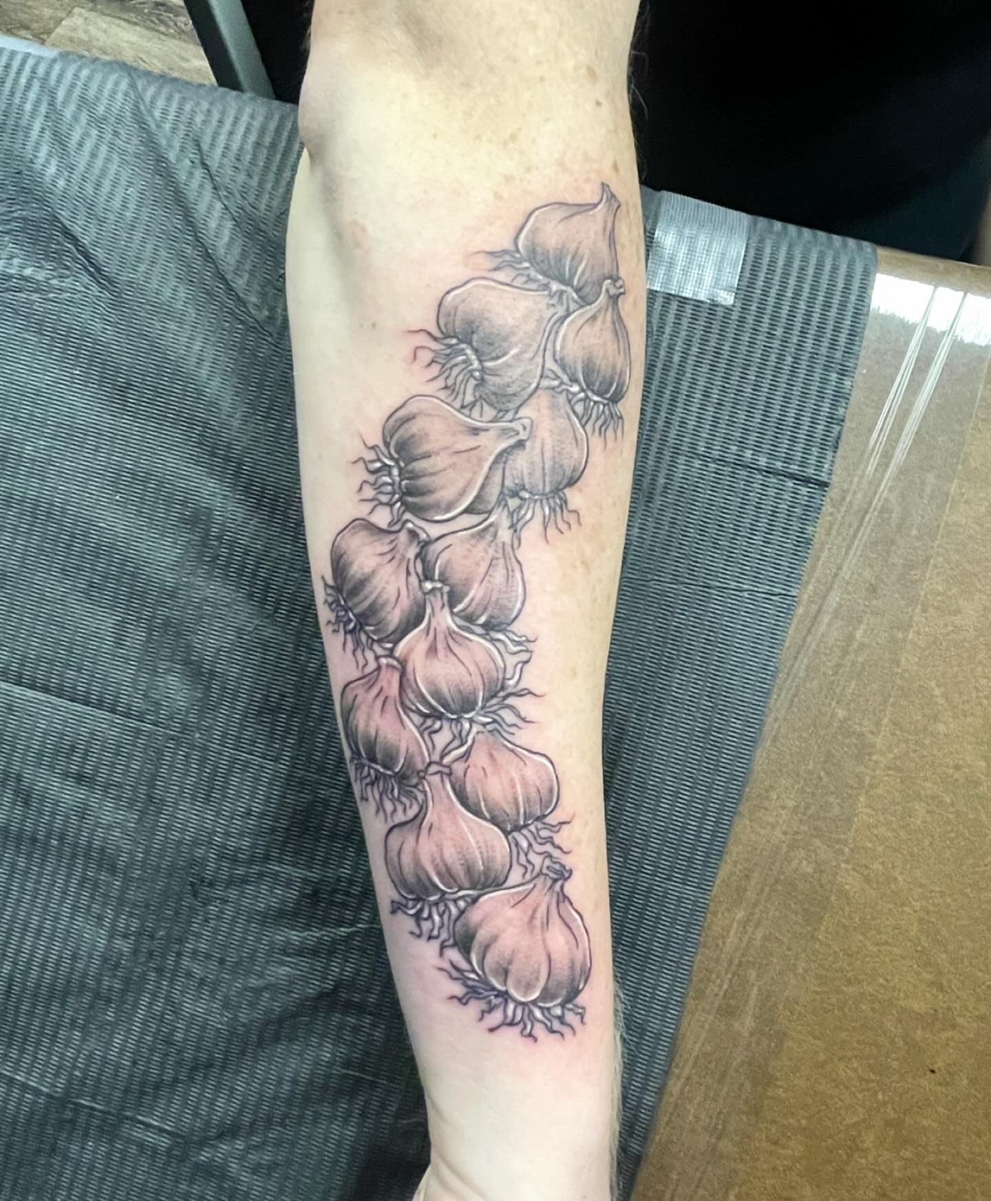 Garlic bunch black and grey tattoo on the forearm by Mark Calloway