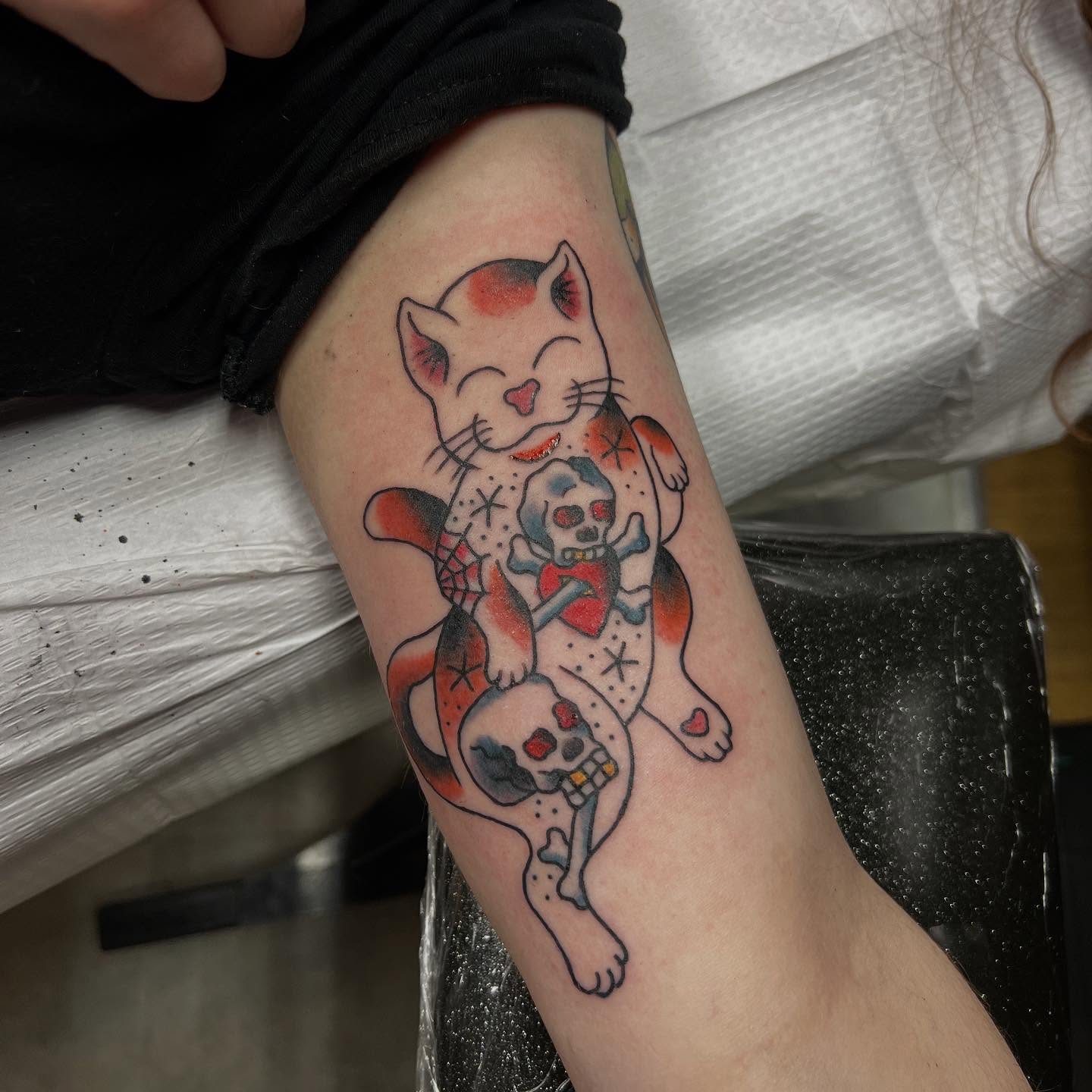 Cat and skull American traditional tattoo on the forearm by doodle