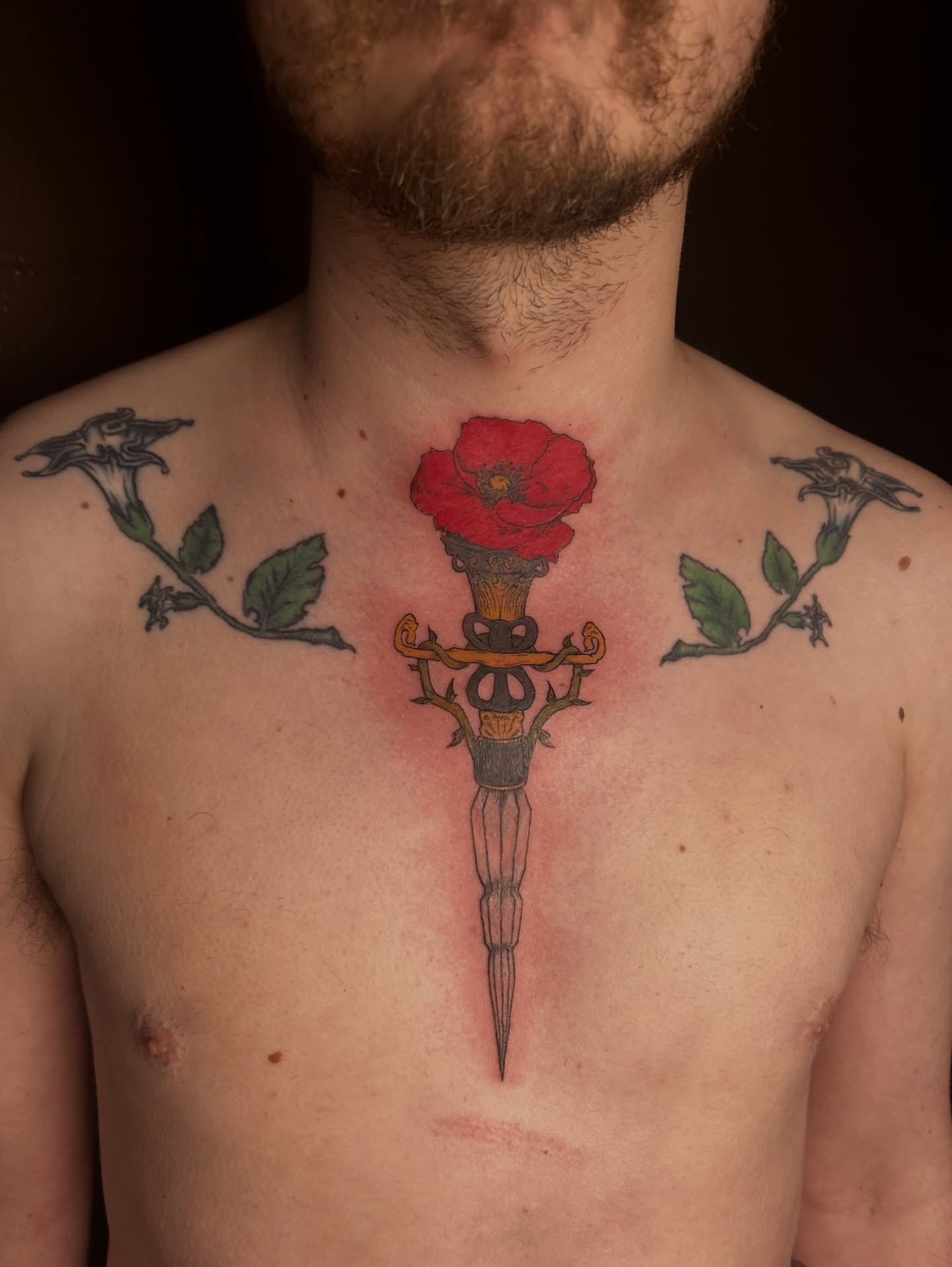 Sword and poppy neo-traditional tattoo on the chest by King By Trade 👑