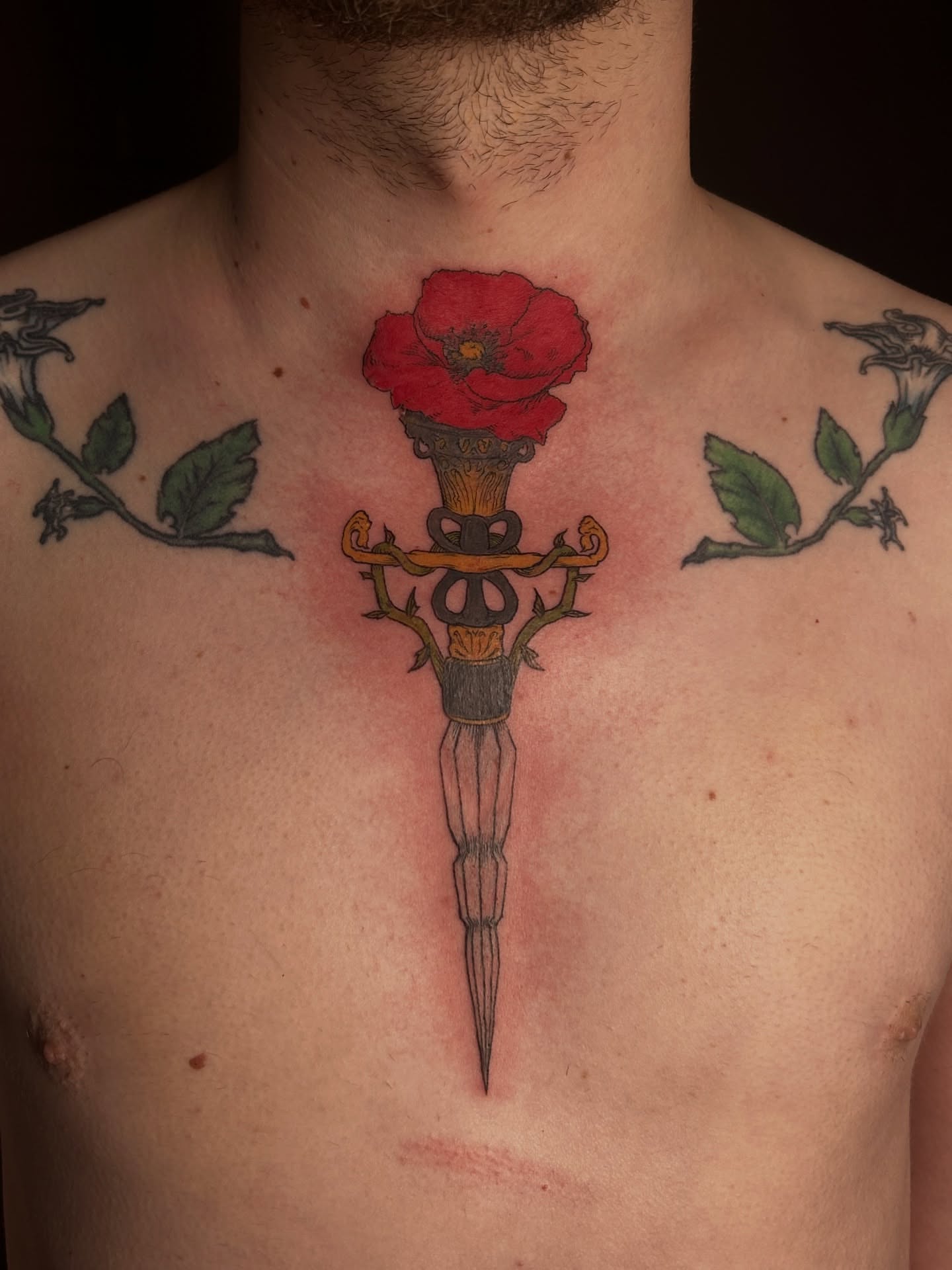 Sword and poppy neo-traditional tattoo on the chest by King By Trade 👑