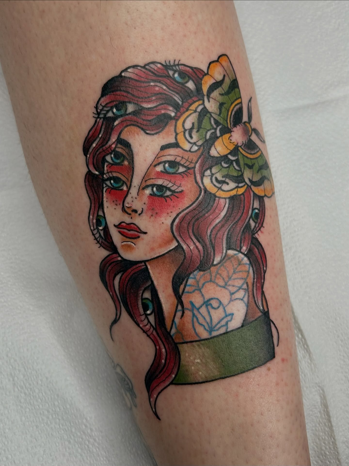 Woman with flowers American traditional tattoo on the forearm by Noah Crow