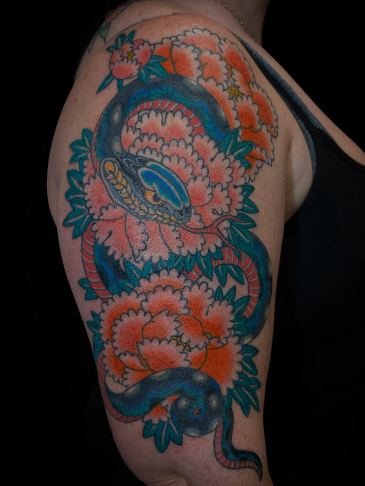 Snake and peony American traditional tattoo on the shoulder by Angela Mukai