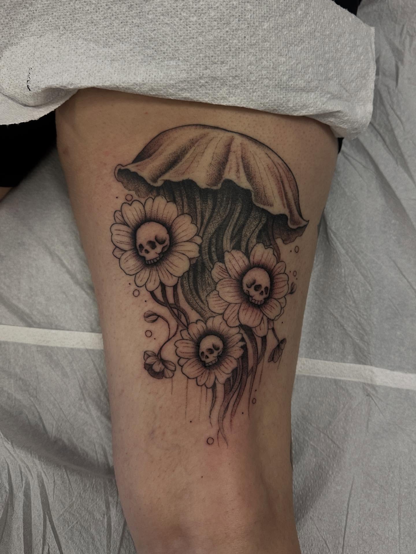Jellyfish and flowers black and grey tattoo on the thigh by Matt Kearney