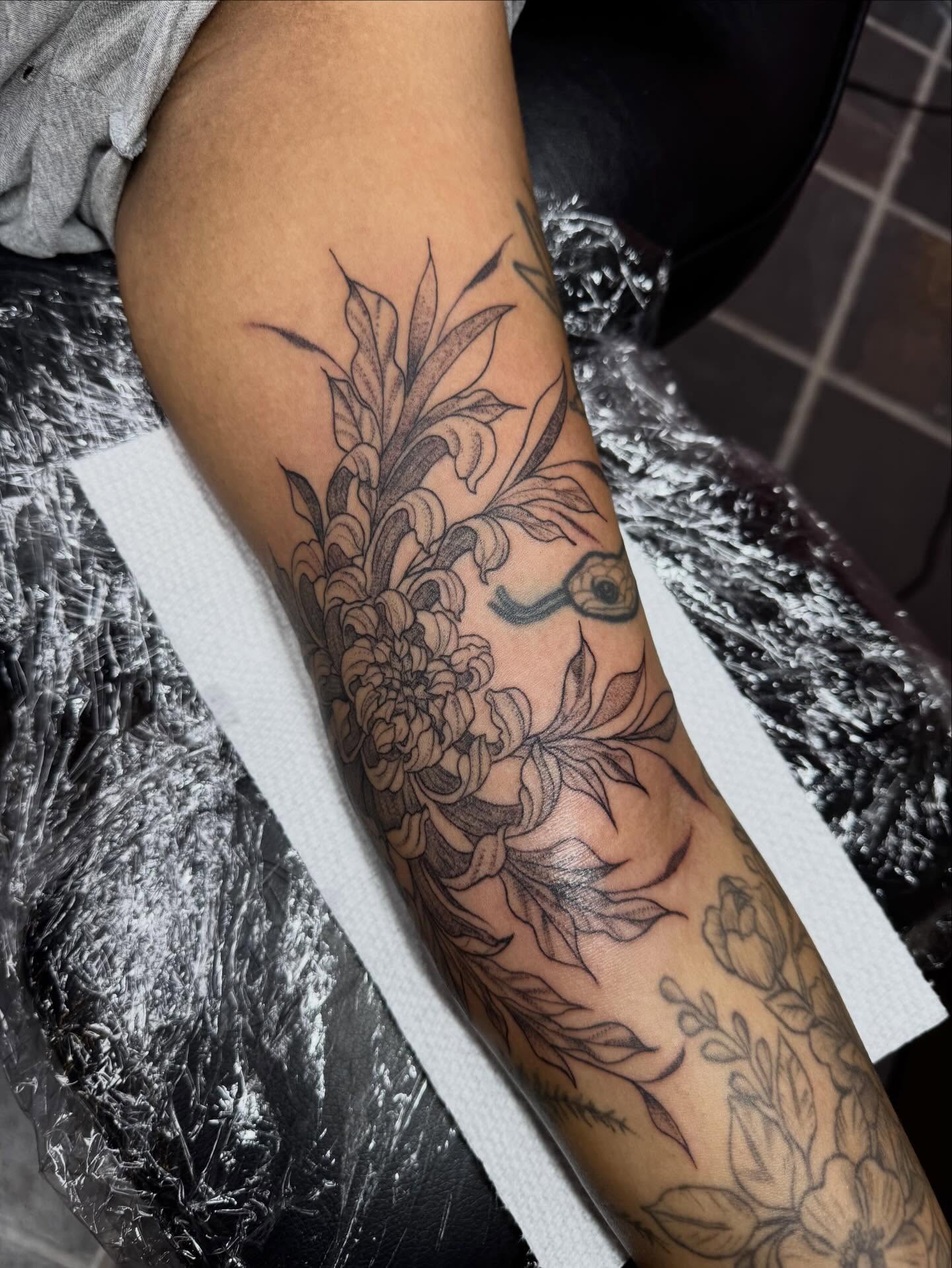 Floral arrangement realism tattoo on the forearm by olivia reed