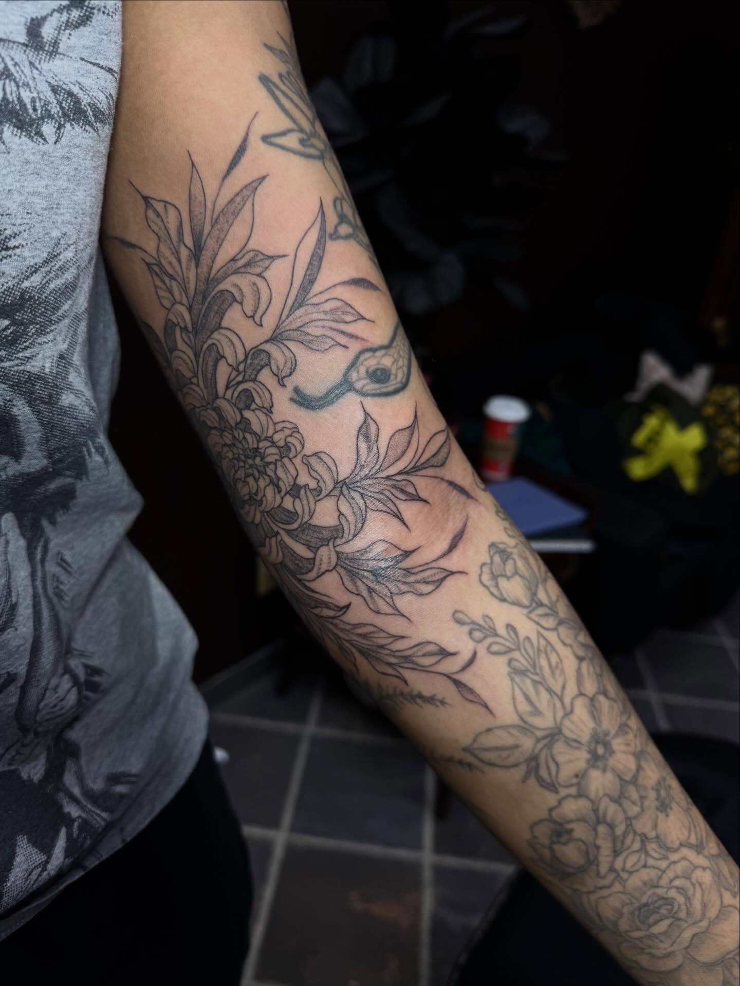 Floral and bird black and grey tattoo on the forearm by olivia reed