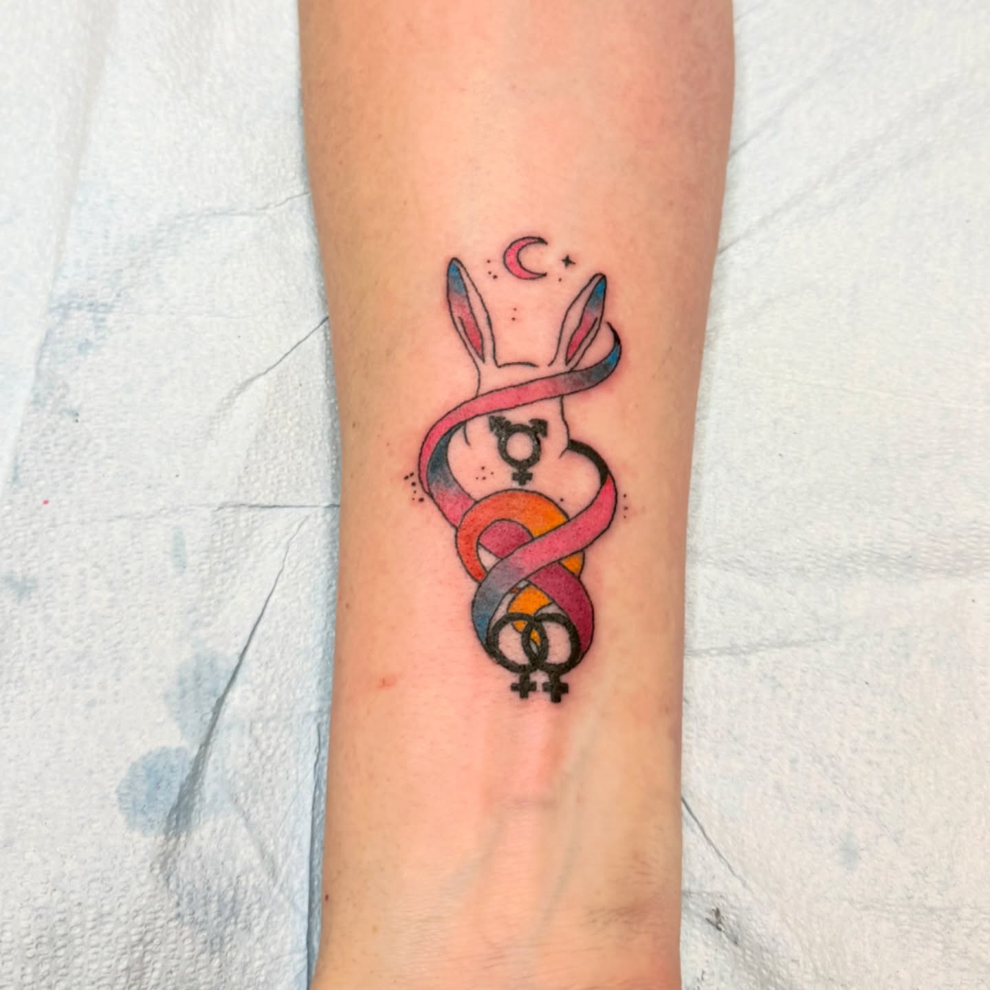 Gender symbols and rabbit ears dotwork tattoo on the forearm by Emma Berger