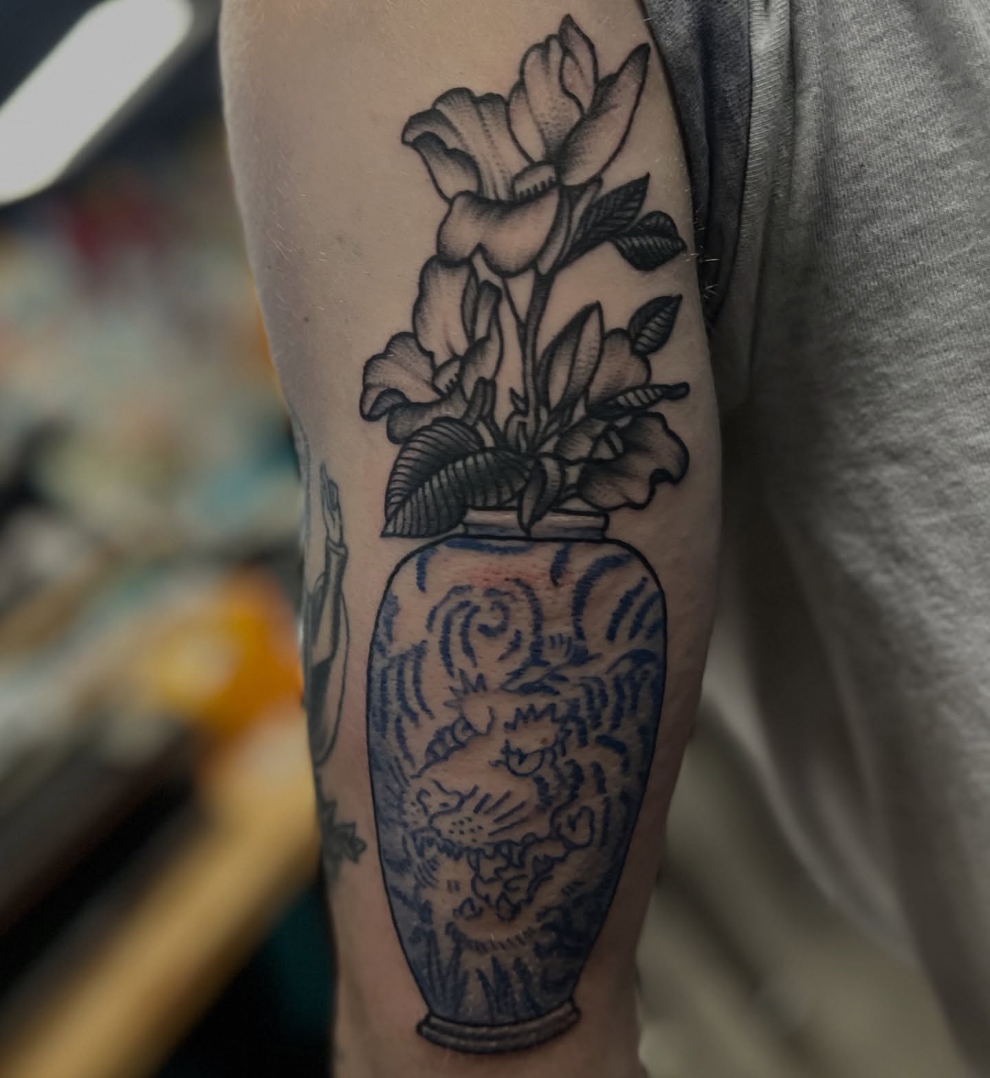 Vase with flowers black and grey tattoo on the forearm by Ashley Camp