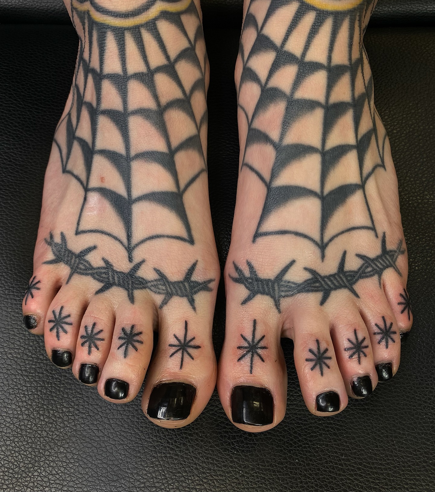 Spiderweb and barbed wire geometric tattoo on the foot by Corinne Carter