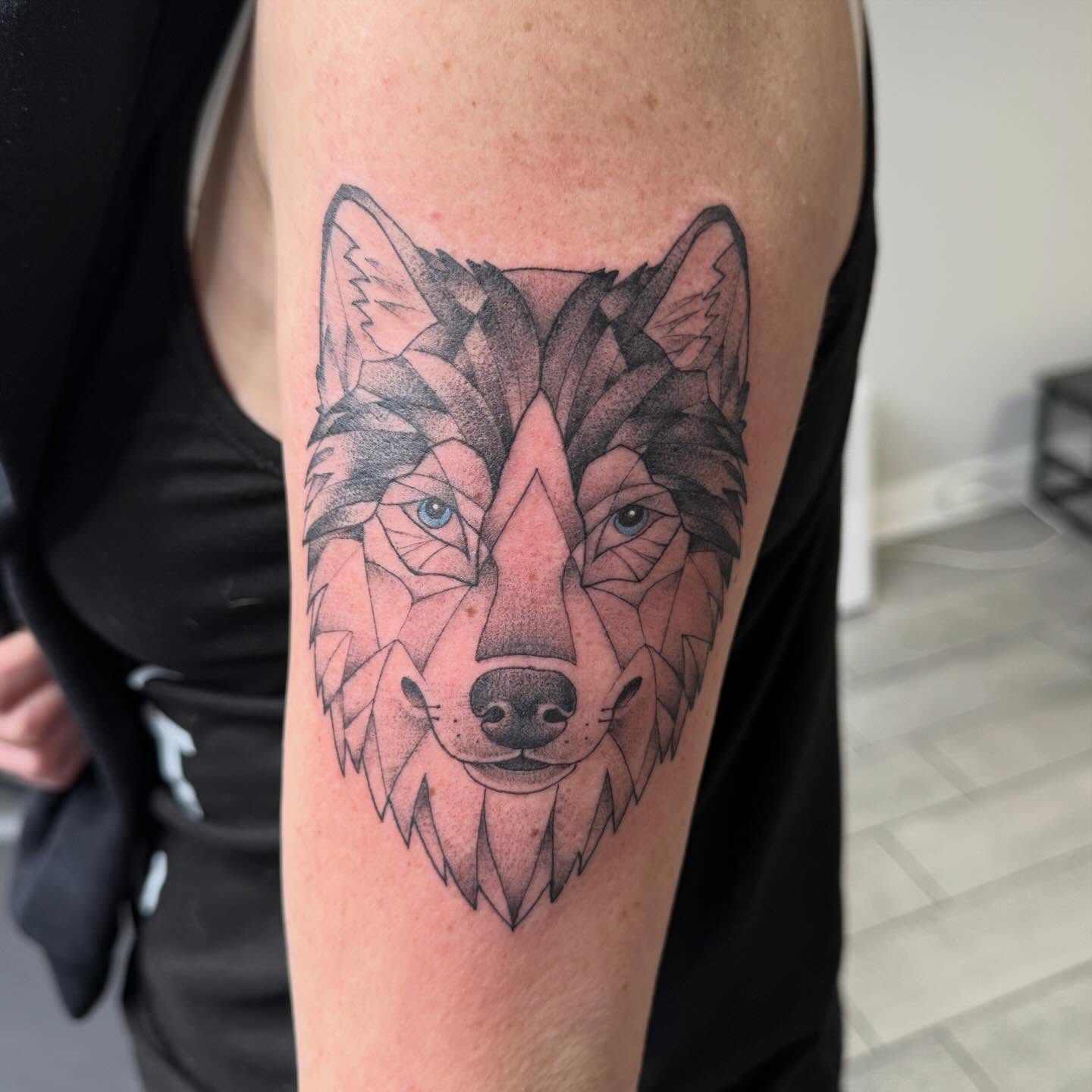 Wolf geometric tattoo on the forearm by Joey Flaherty