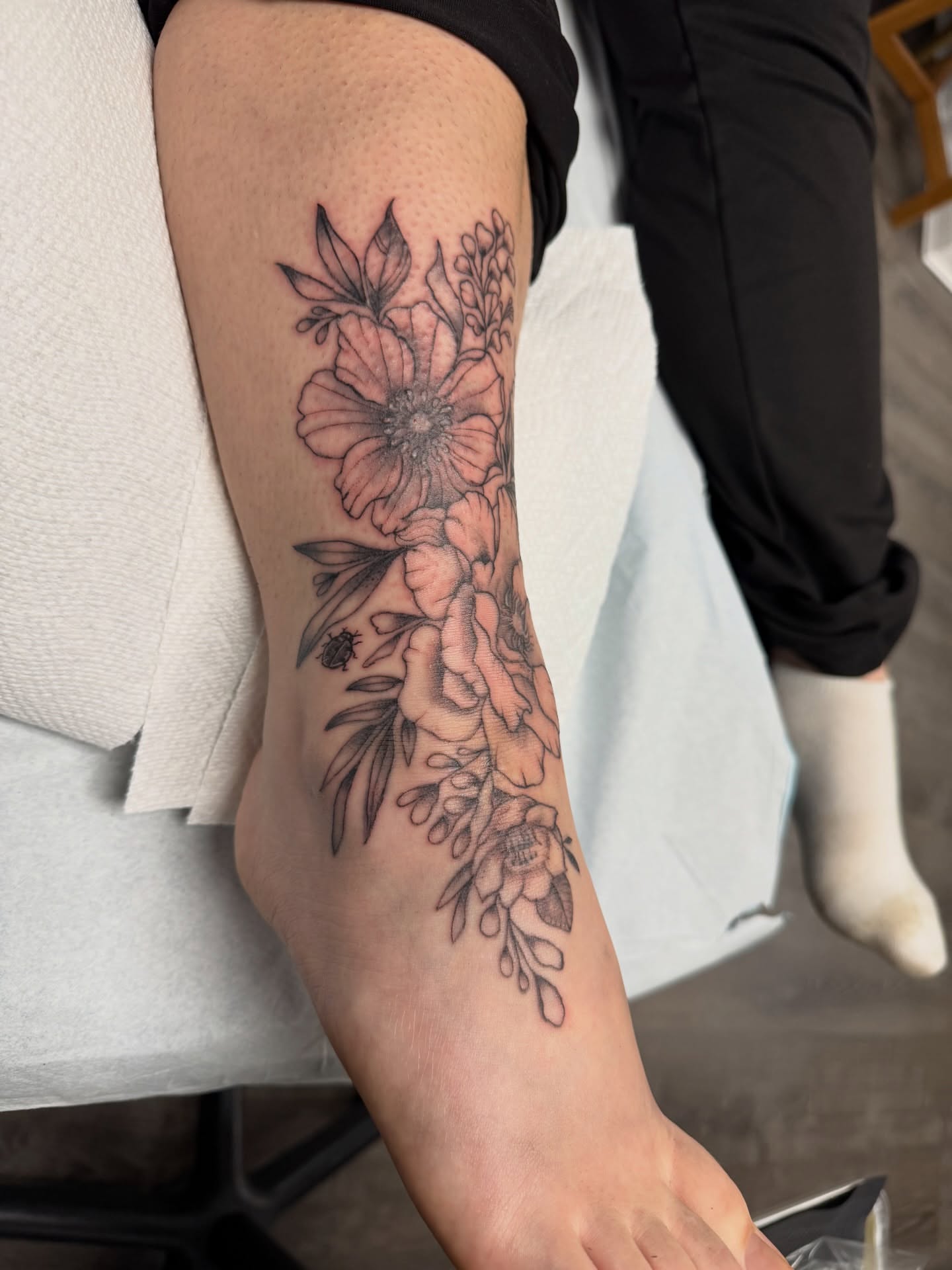 Floral arrangement black and grey tattoo on the leg by Deni Carolina