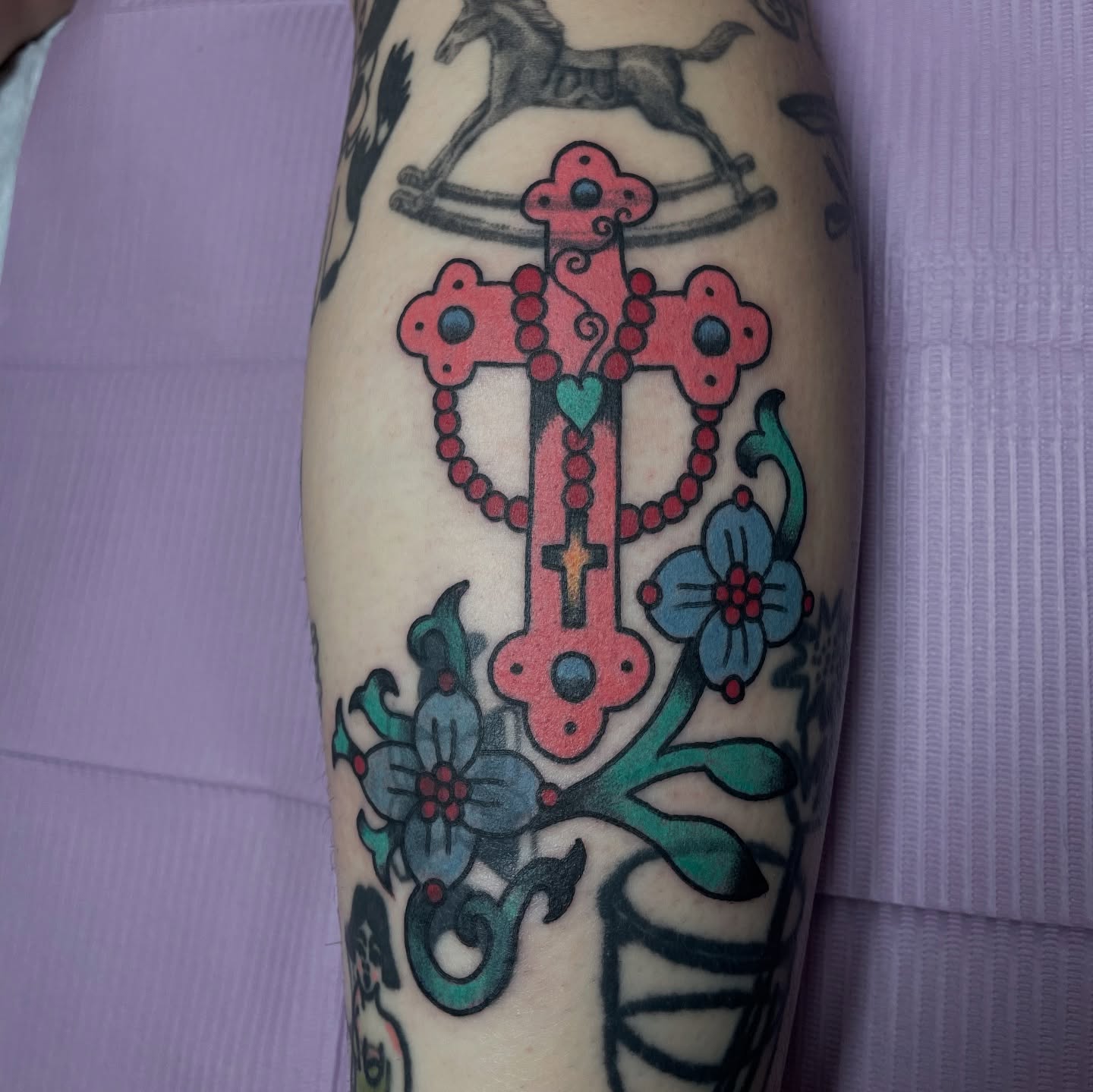 Cross with floral elements American traditional tattoo on the forearm by zoe ๐