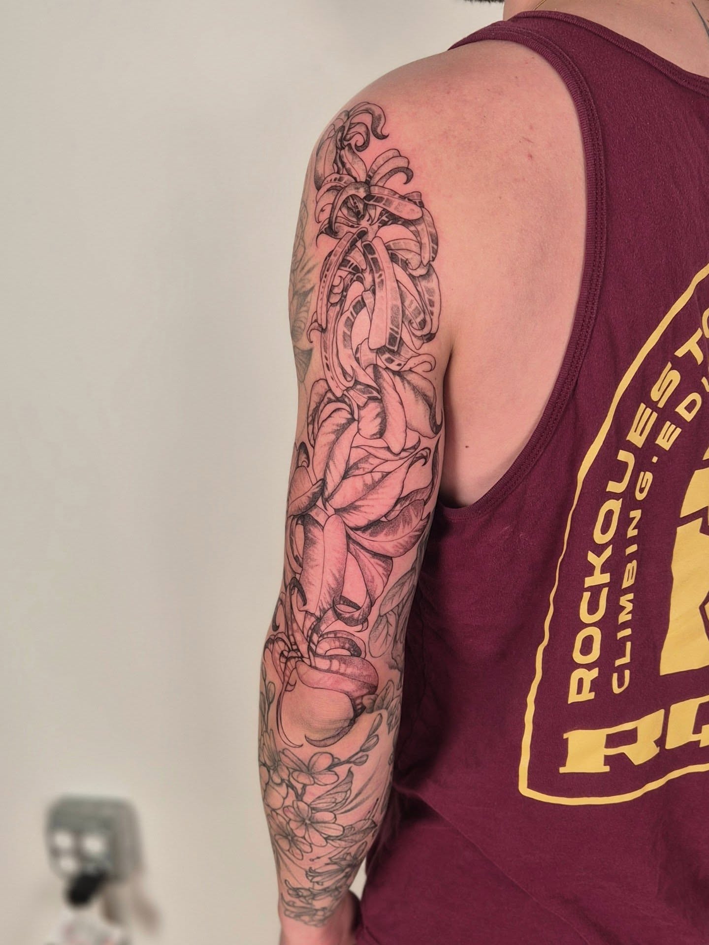 Floral and mechanical neo-traditional tattoo on the upper arm by Sophorn Long (soapy)
